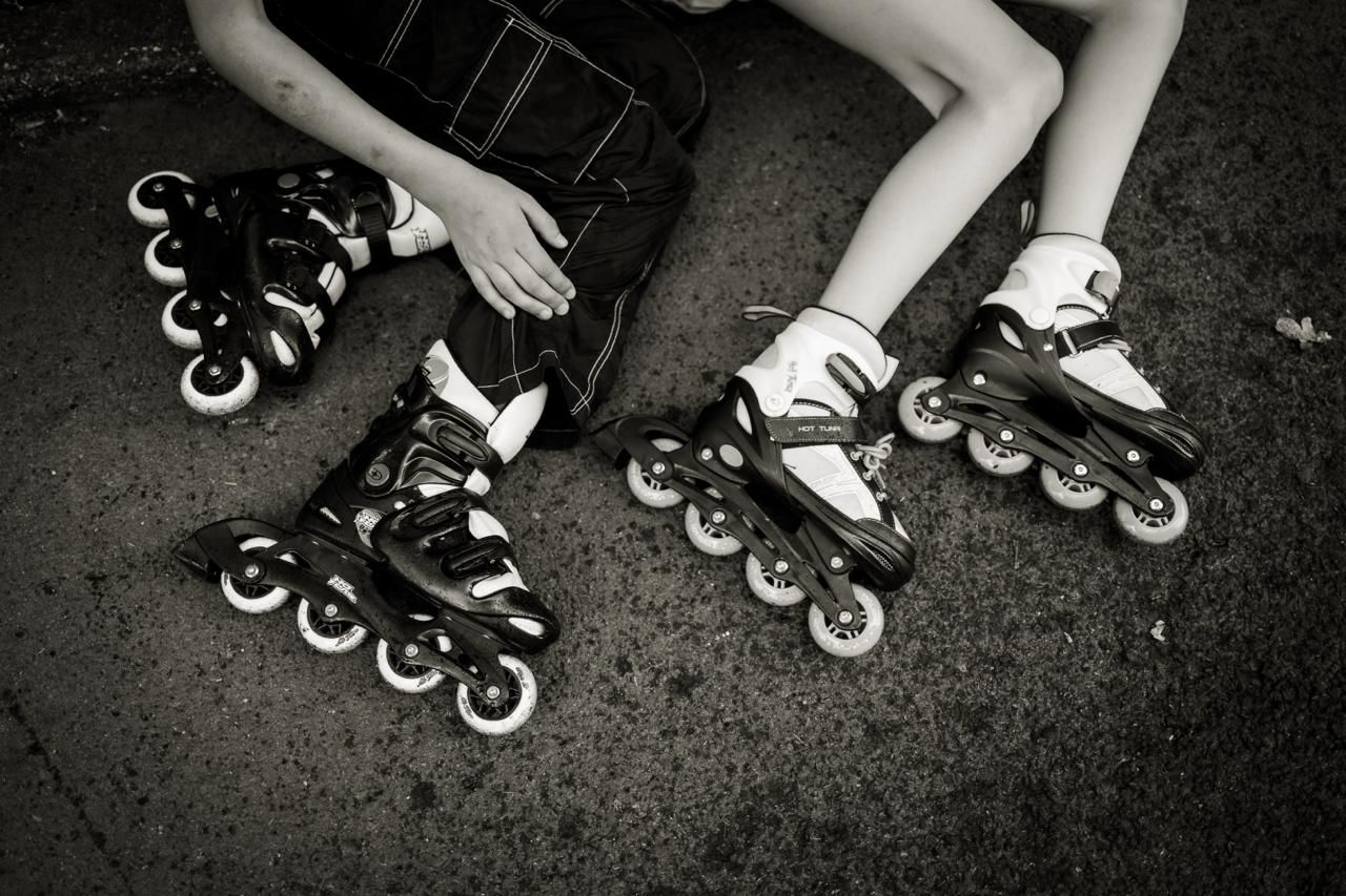 Black and white image of roller blades, highlighting simple and repetitive round shape of the wheels.