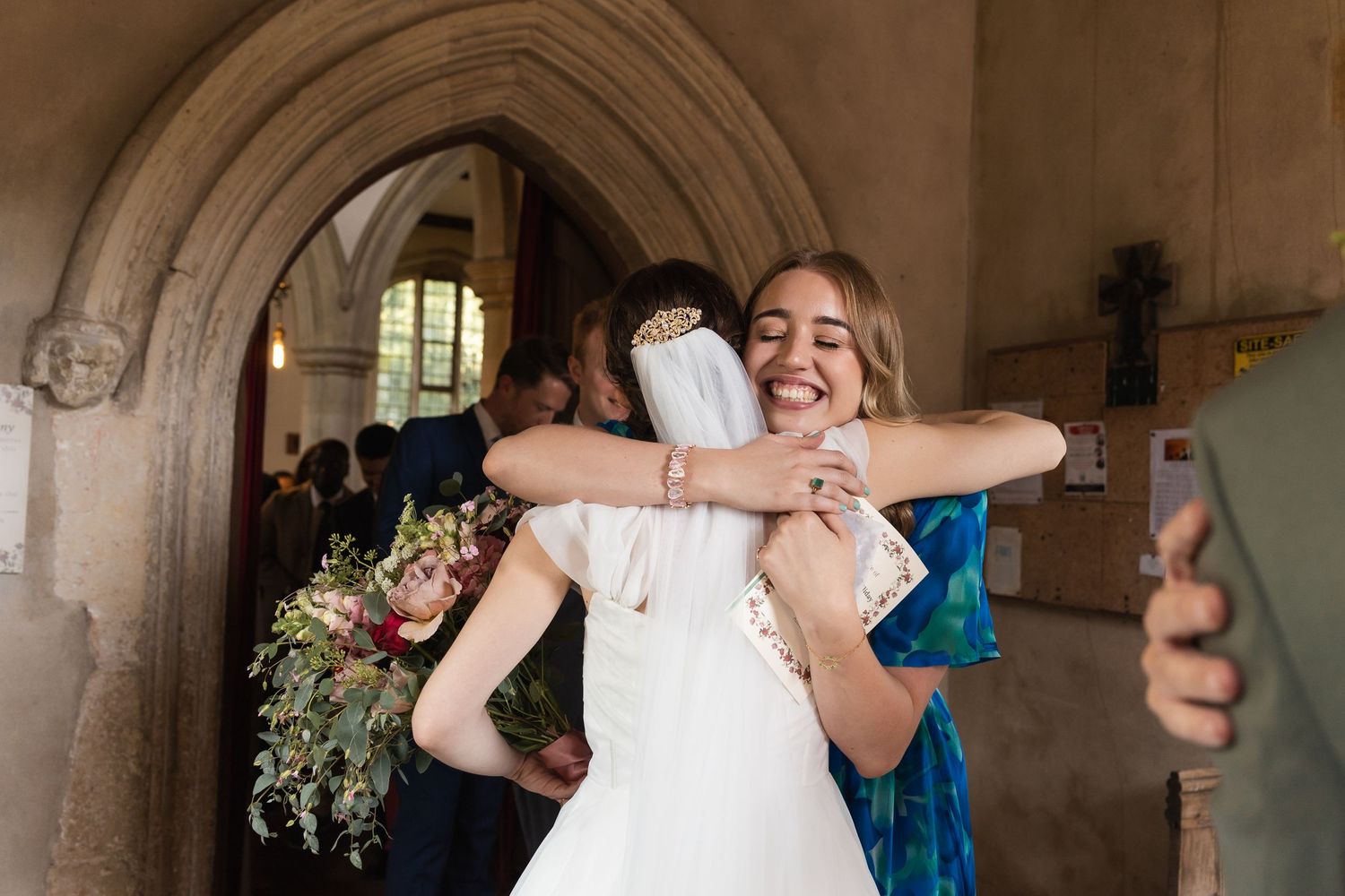 Just outside the church, the newly wed bride hugs her guest, in Ware, Hertfordshire.