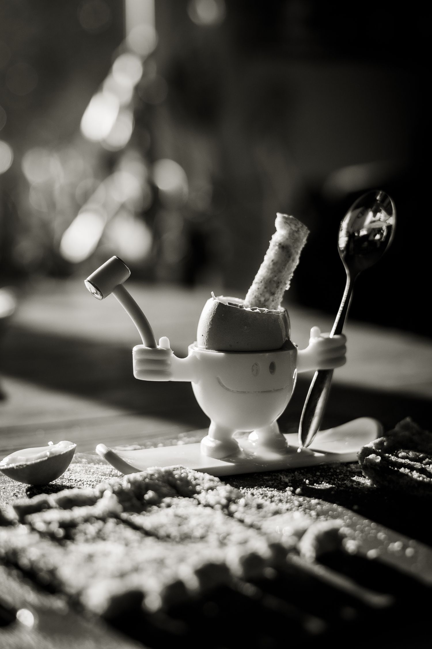 Black and white image with beautiful harsh light shining on egg and soldiers at Barnet home.