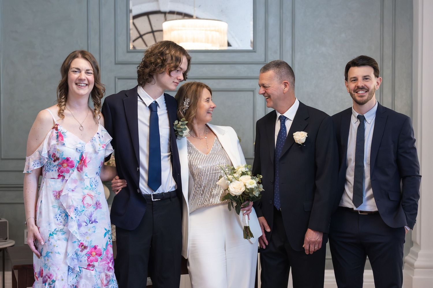 Relaxed group photo post ceremony, where the family are not looking at the camera but are all smiling and interacting with each other.