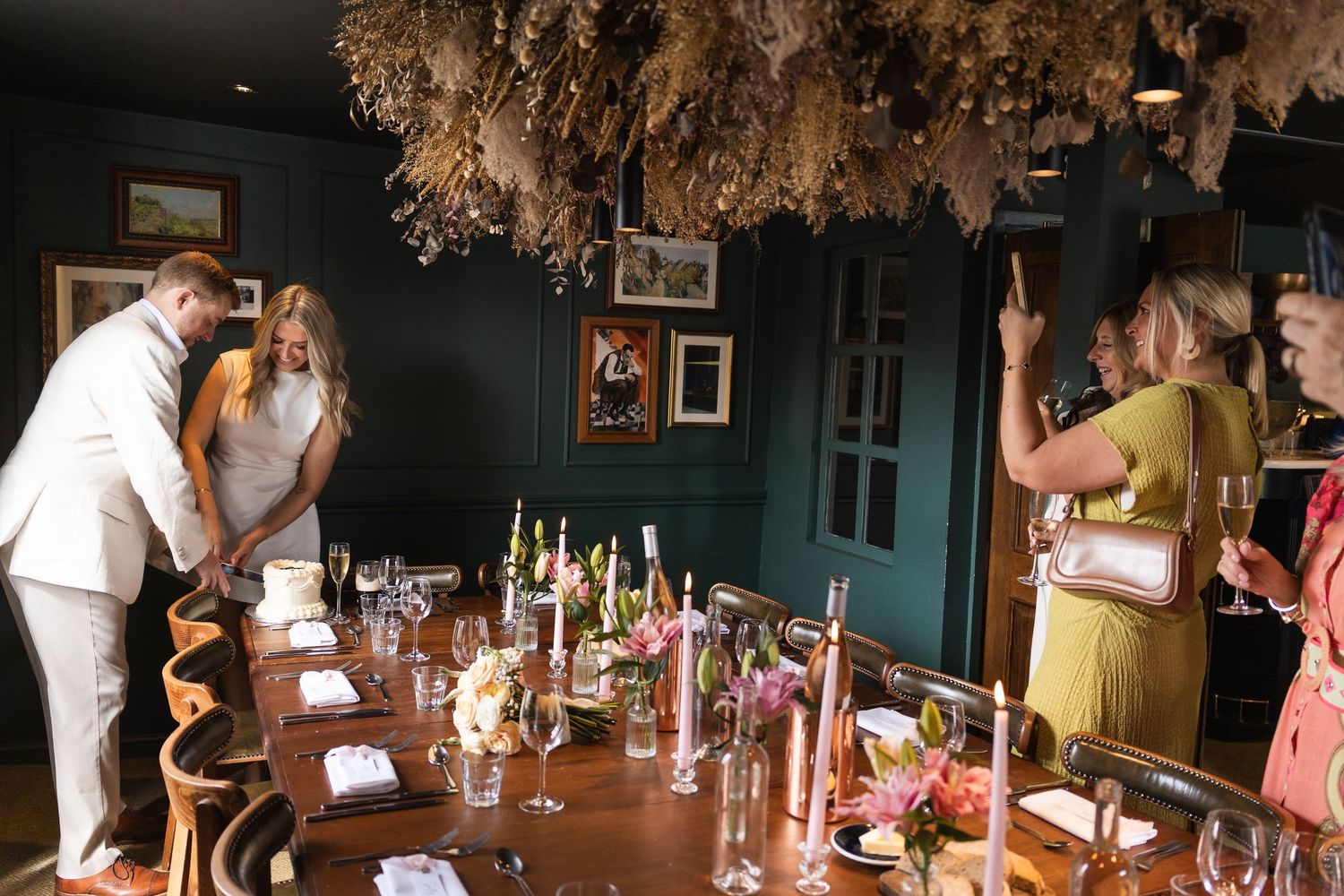 Documentary photography of bride and groom cutting the cake at their reception at The Phene in West London.