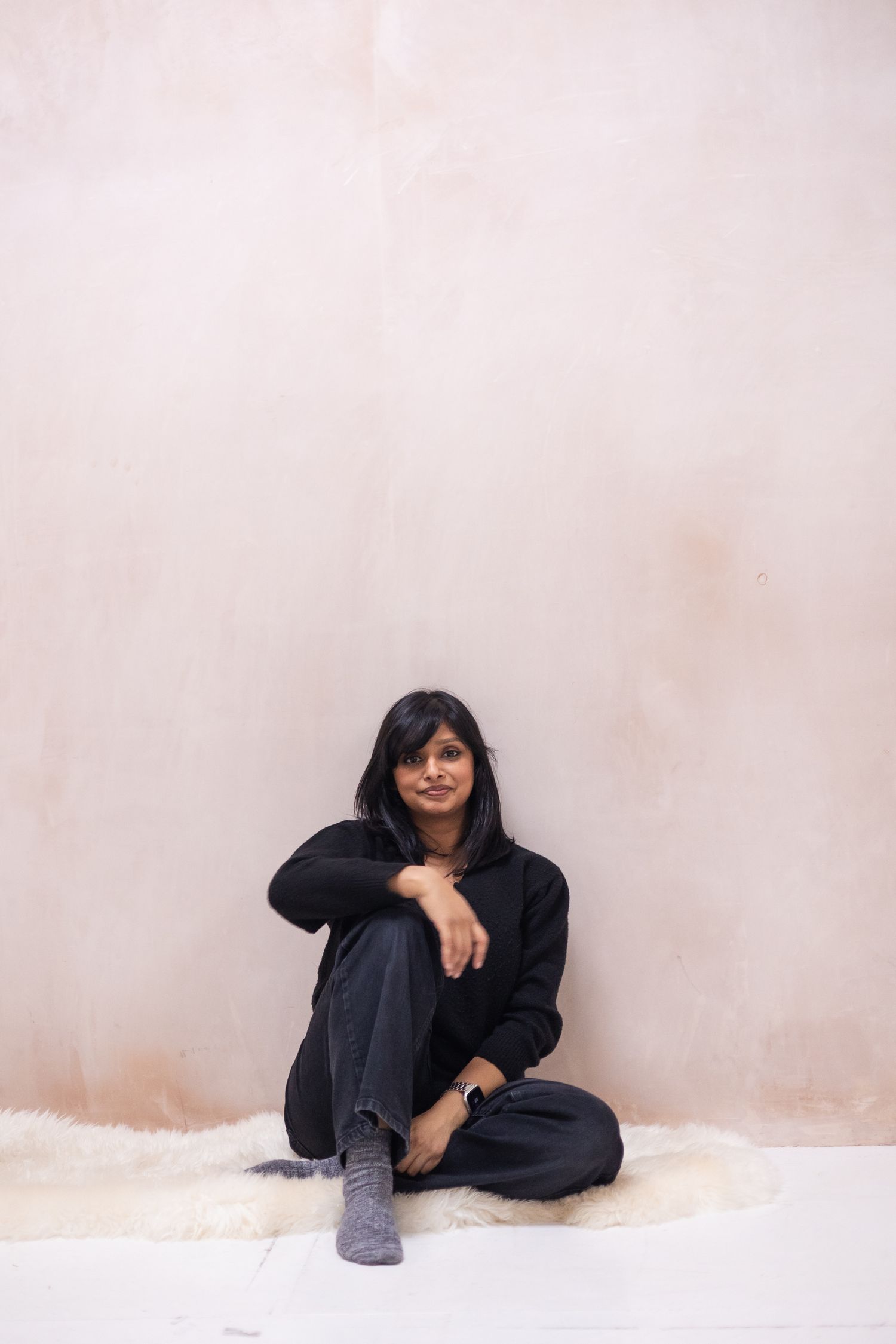 Modern headshot, taken in a studio setting against a freshly plastered wall, that feels natural and unforced.