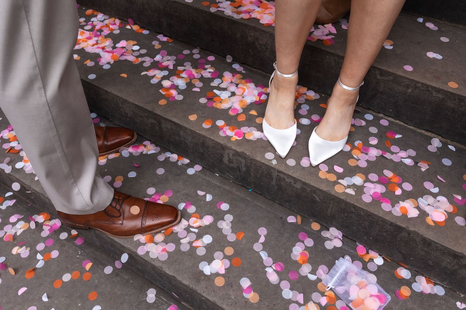 Image on the steps of London Town Hall. of bride and groom shoes and loads of colourful confetti on the ground.