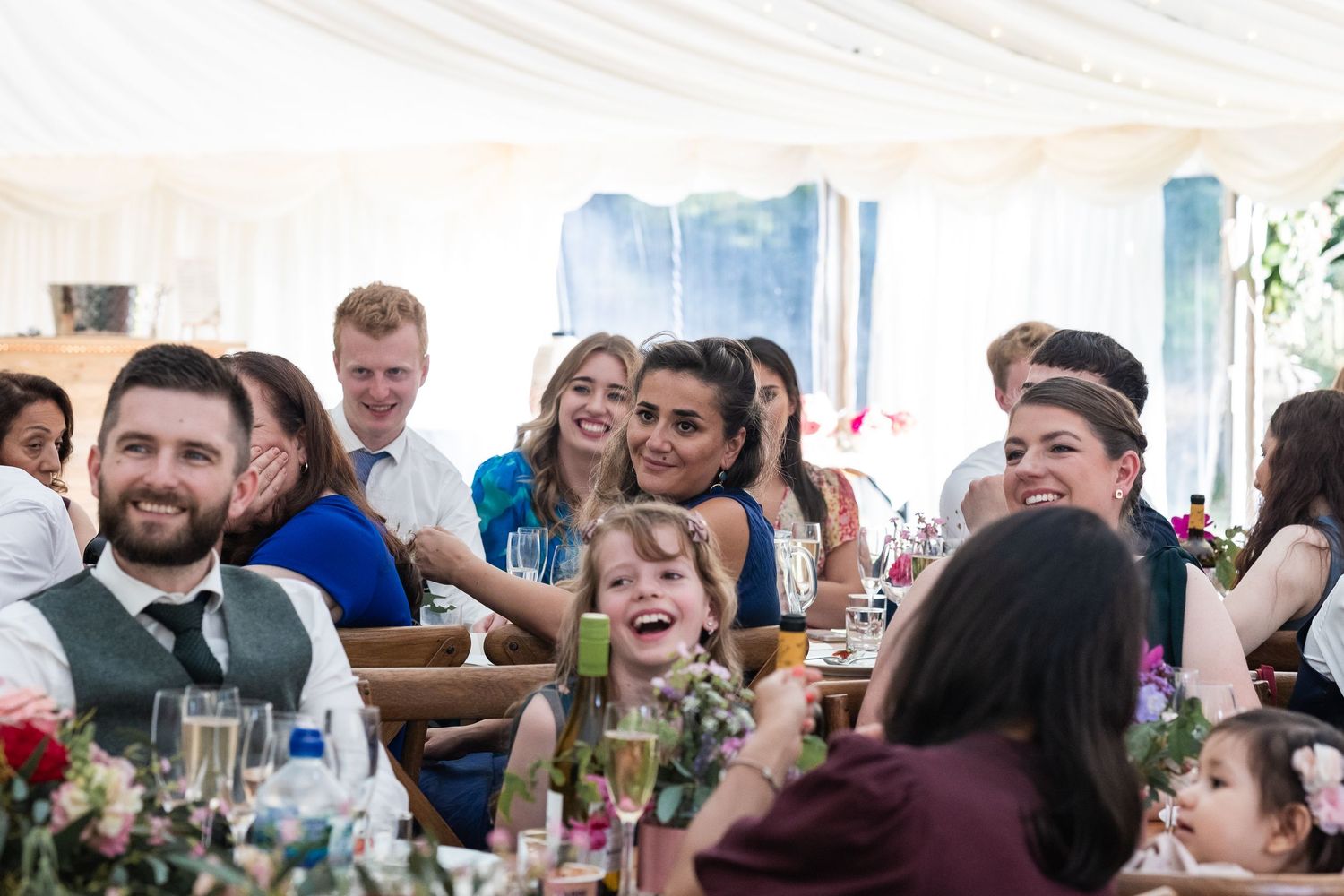 Laughter during wedding speeches at the reception, held in the marquee of the parents garden.