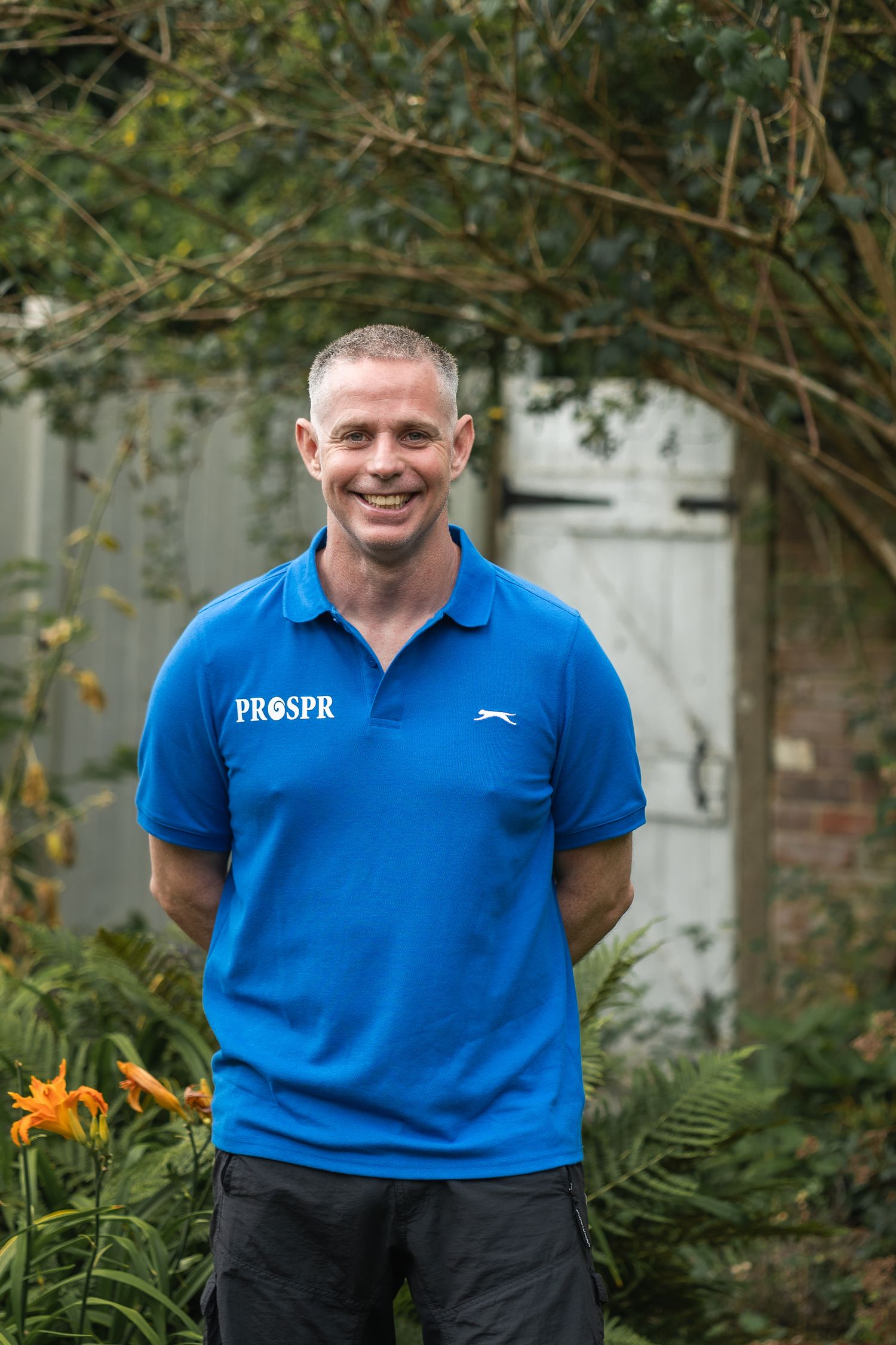 Informal headshot with calm, confident expression, taken in the client's garden.