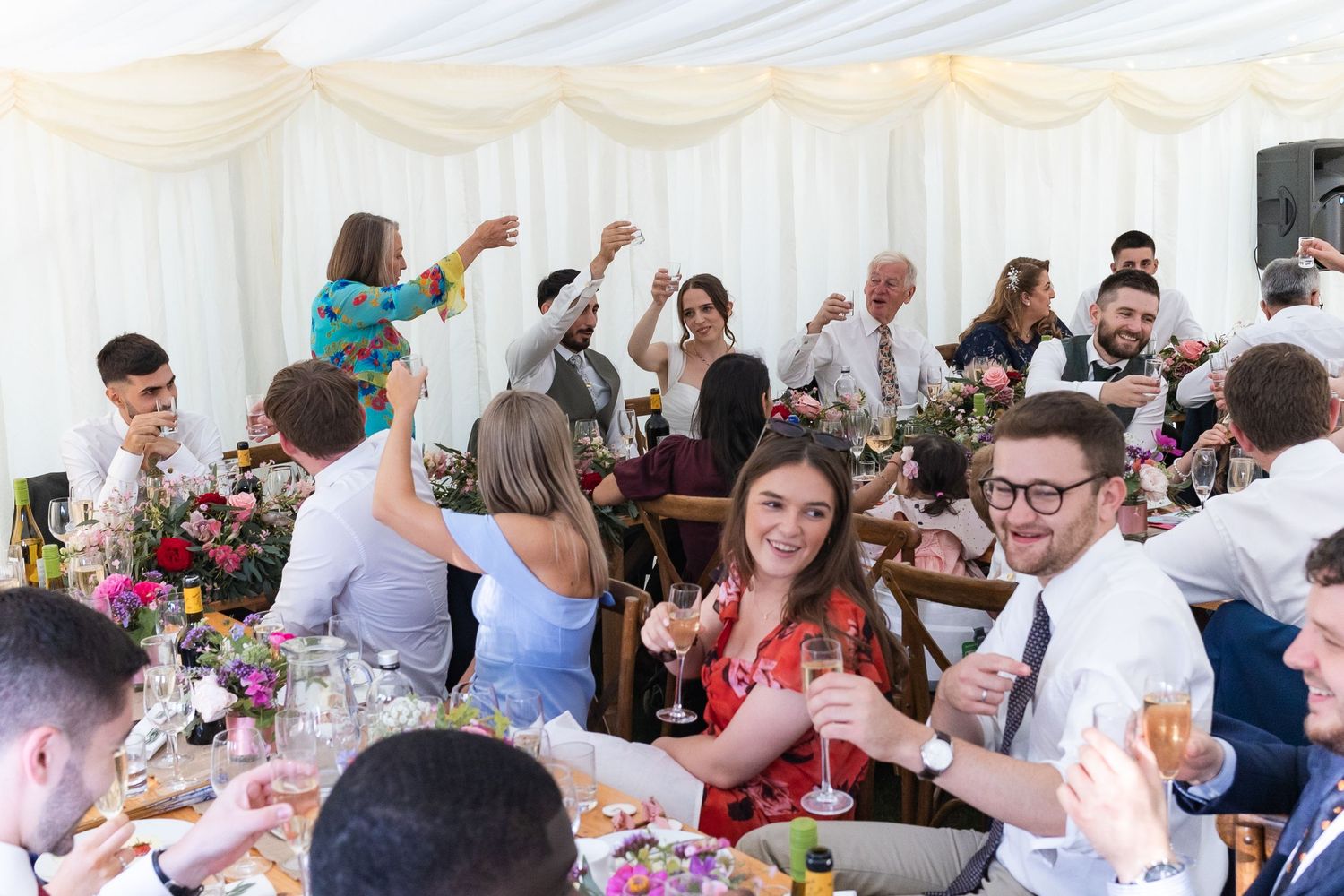 Raising a glass to the newly weds, during the speeches.