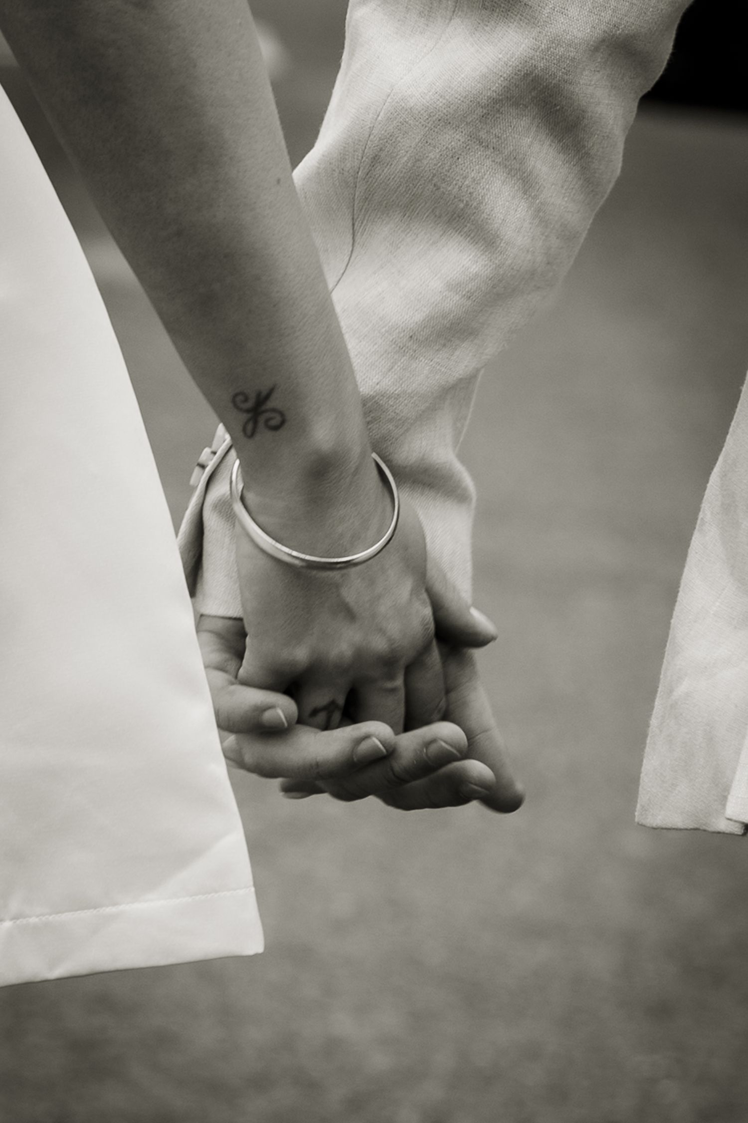 Artistic, slightly blurry for emotional impact, of bride and groom holding hands as they walk.