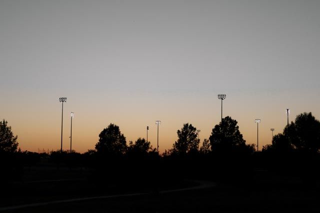 silhouette of a park and Friday night lights.