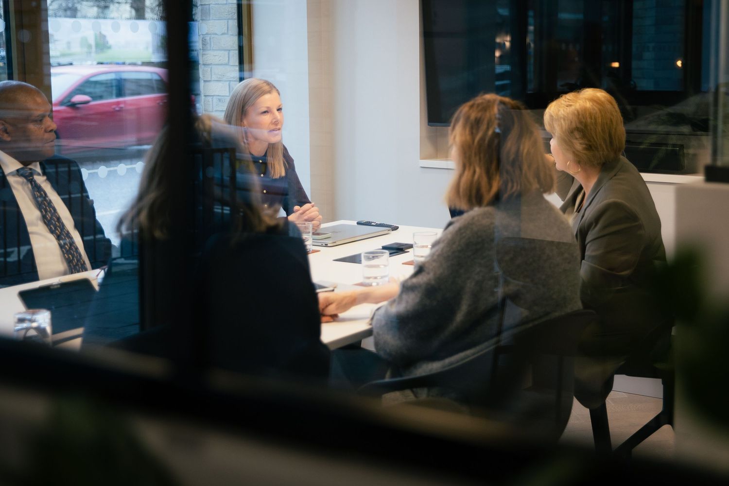 Business professionals engaged in a productive meeting around a conference table in a modern office setting.
