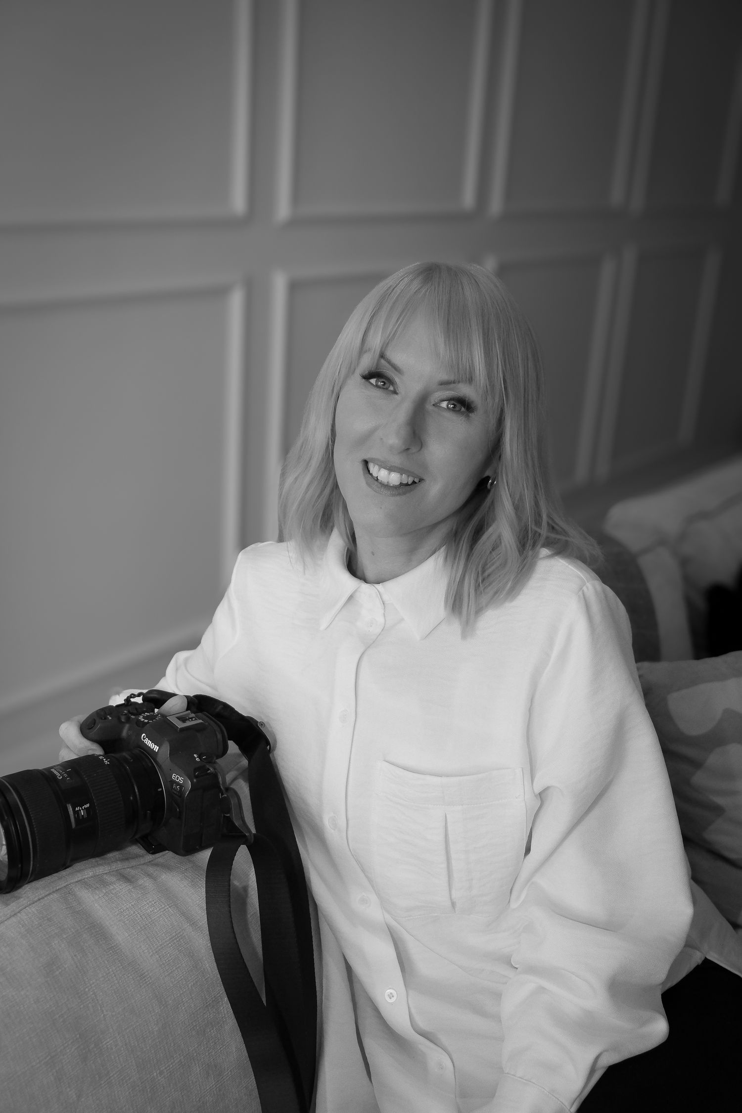 A series of black and white photos showing someone in a white sweater sitting against a light colored wall.