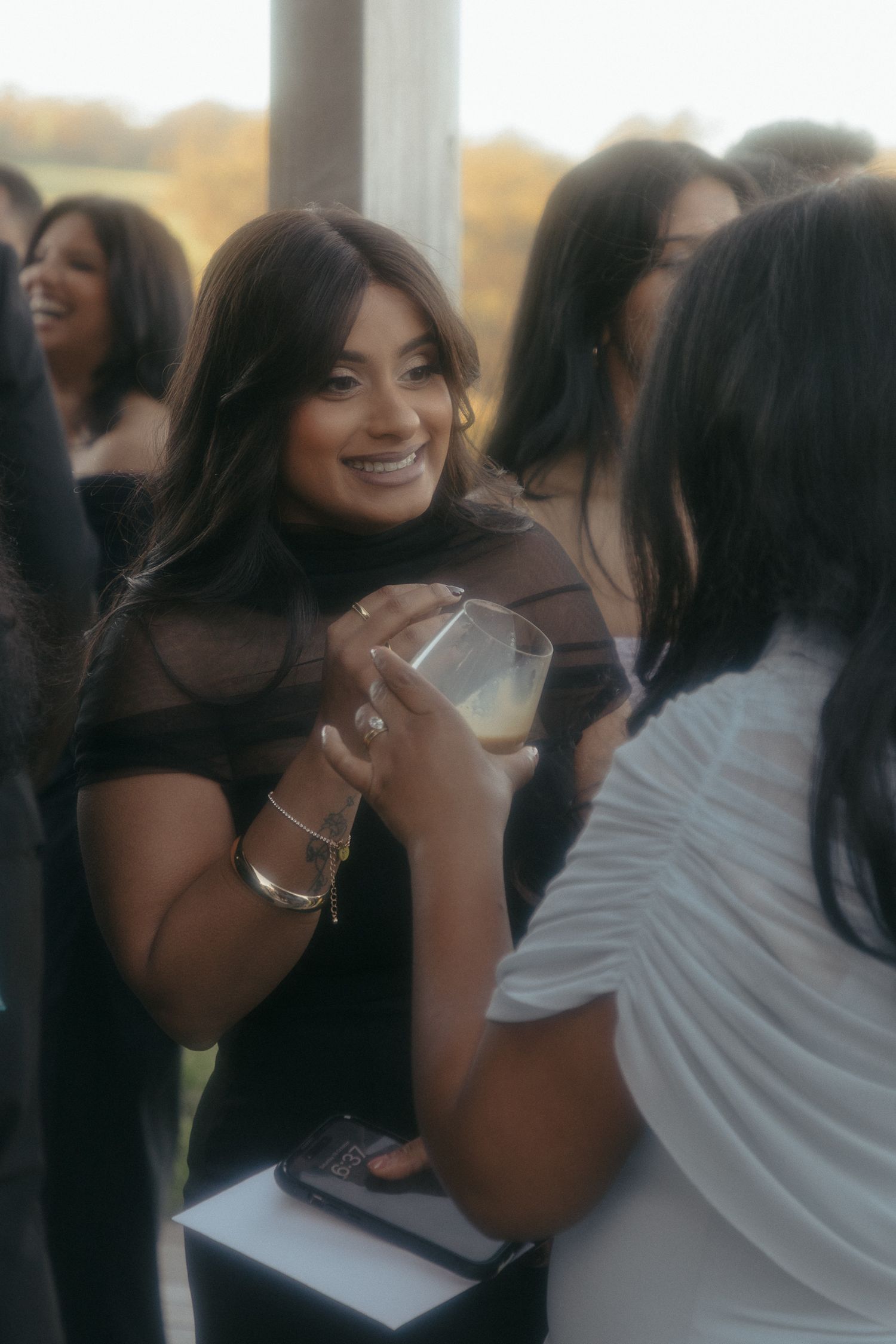 A group of wedding guests share joyful laughter during a celebration.