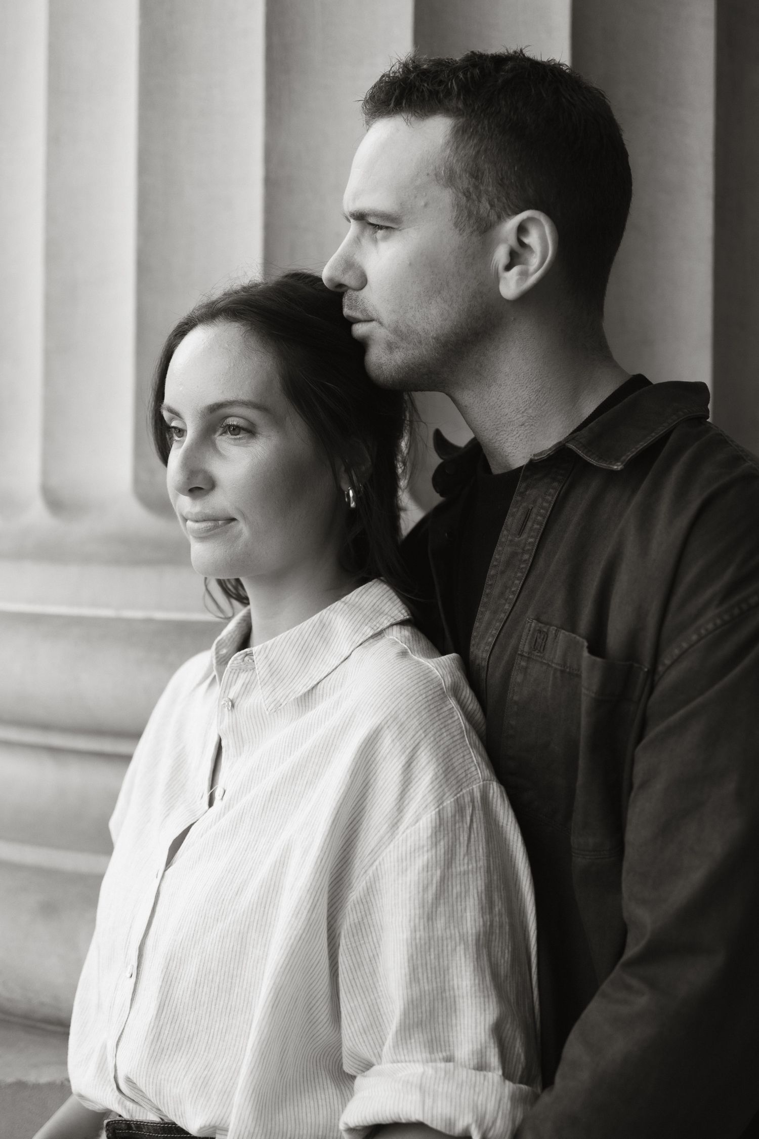 A black and white photo series showing a couple in formal attire posing against white columns.