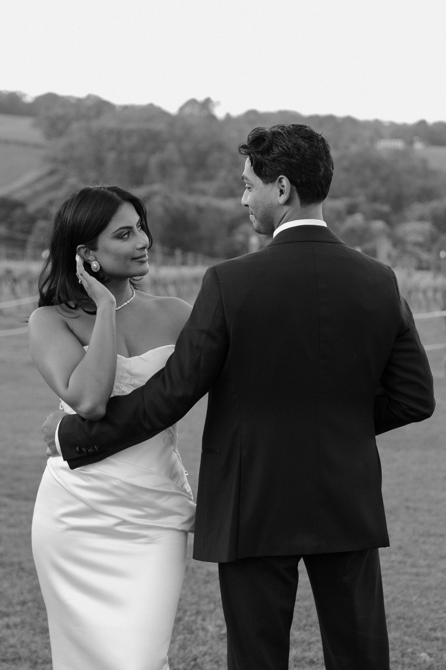 A sequence of black and white wedding photos showing a couple playfully posing together in formal attire.