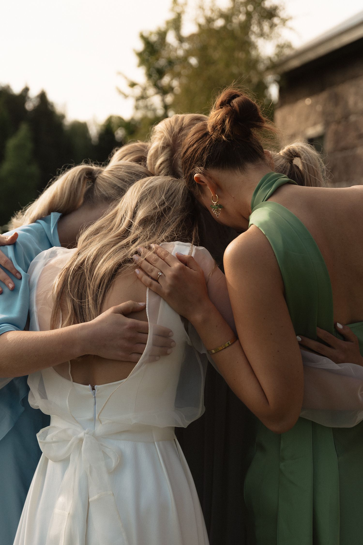 A sequence of photos showing friends comforting and hugging each other in emotional support outdoors at sunset.