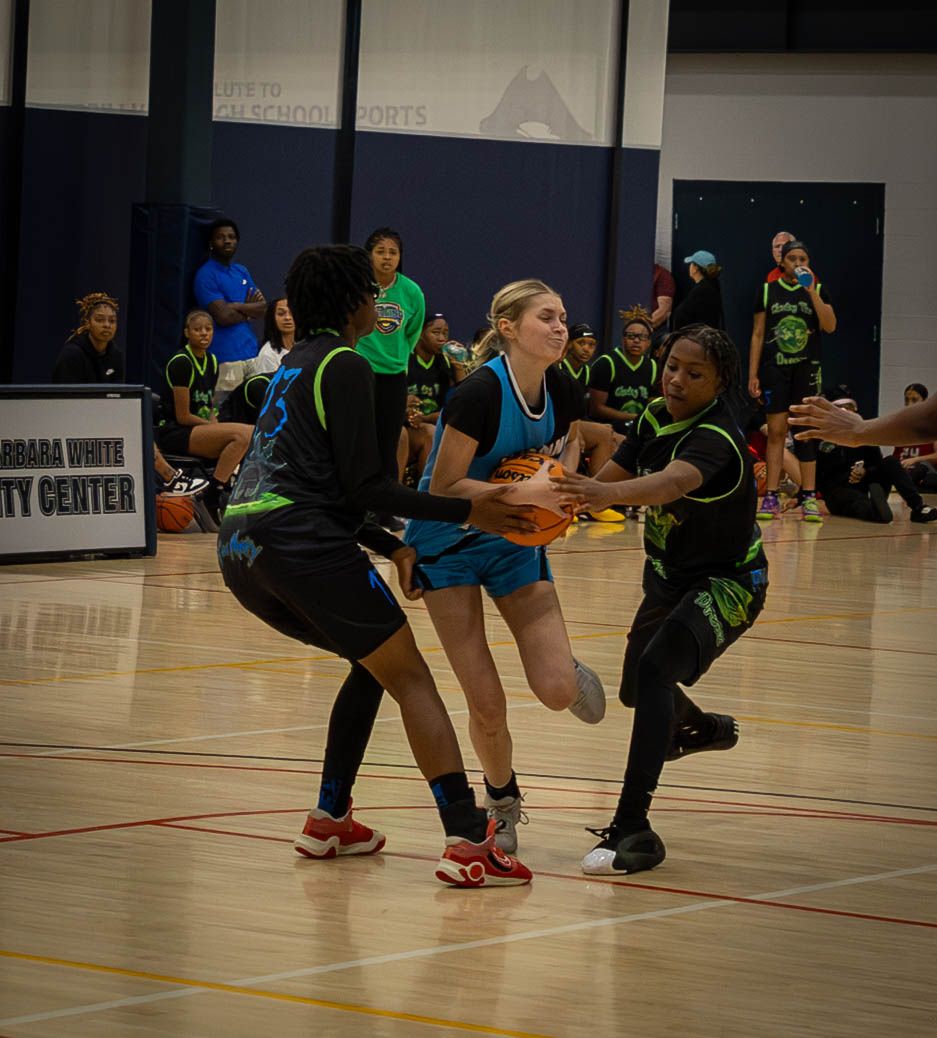 Athletes perform synchronized lunging exercises in a sports facility during a group fitness class.