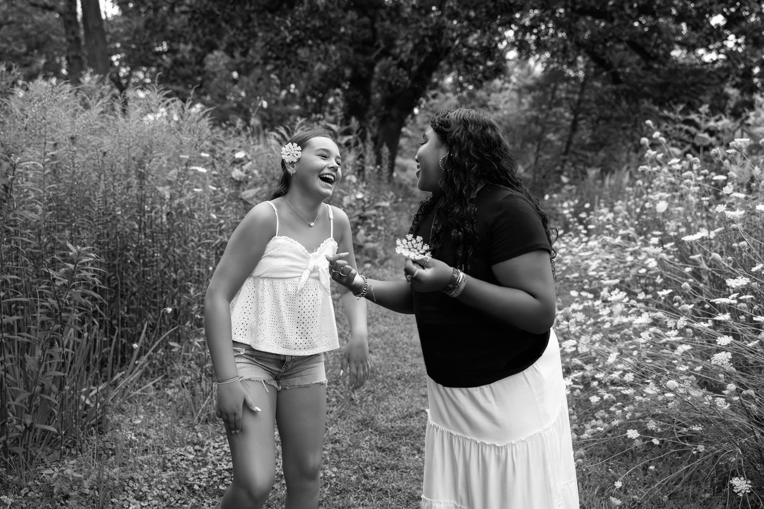 Two people sharing a joyful moment together on an outdoor bridge walkway.