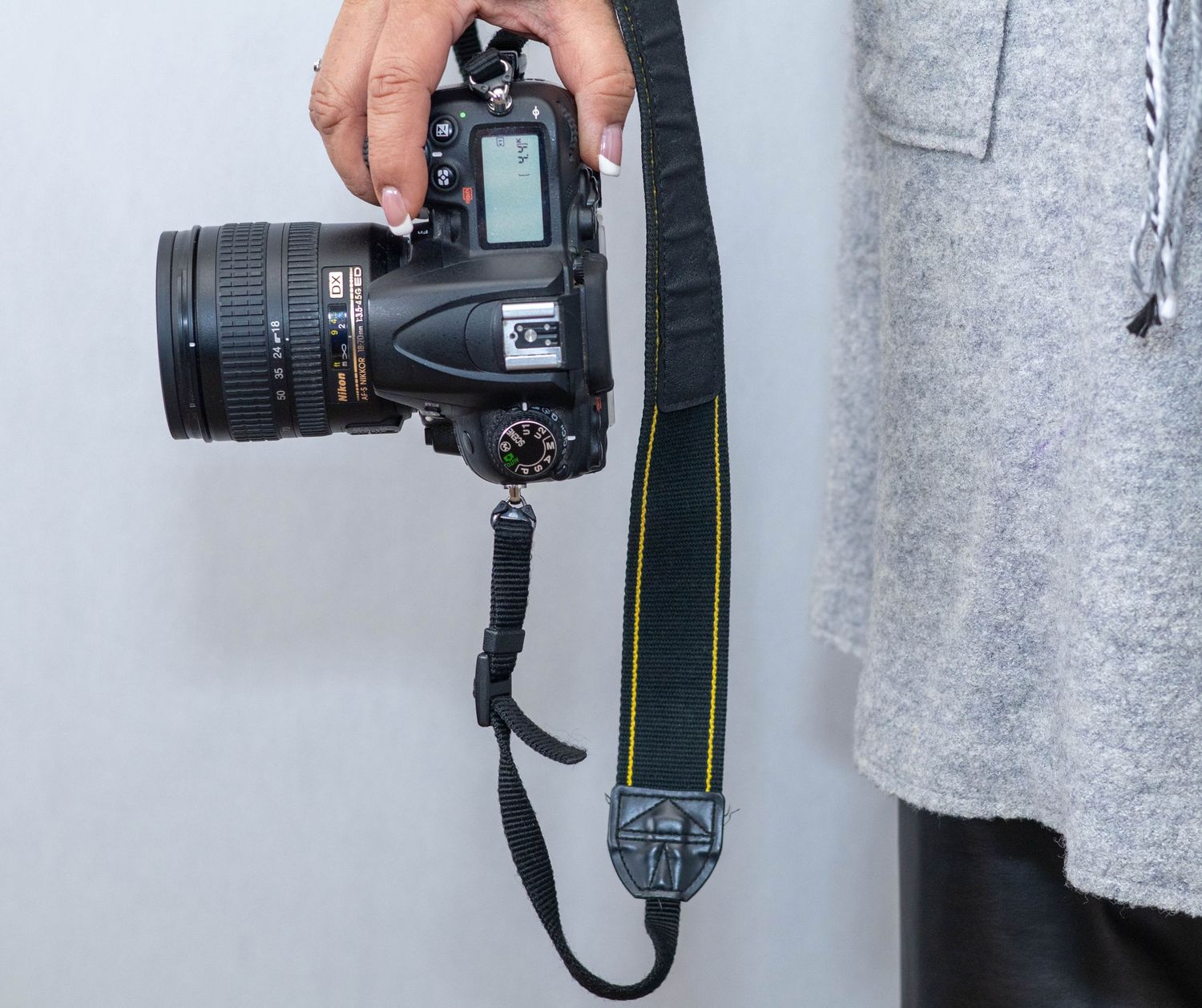 Several DSLR cameras mounted on a gray textured wall, showing professional photography equipment on display.