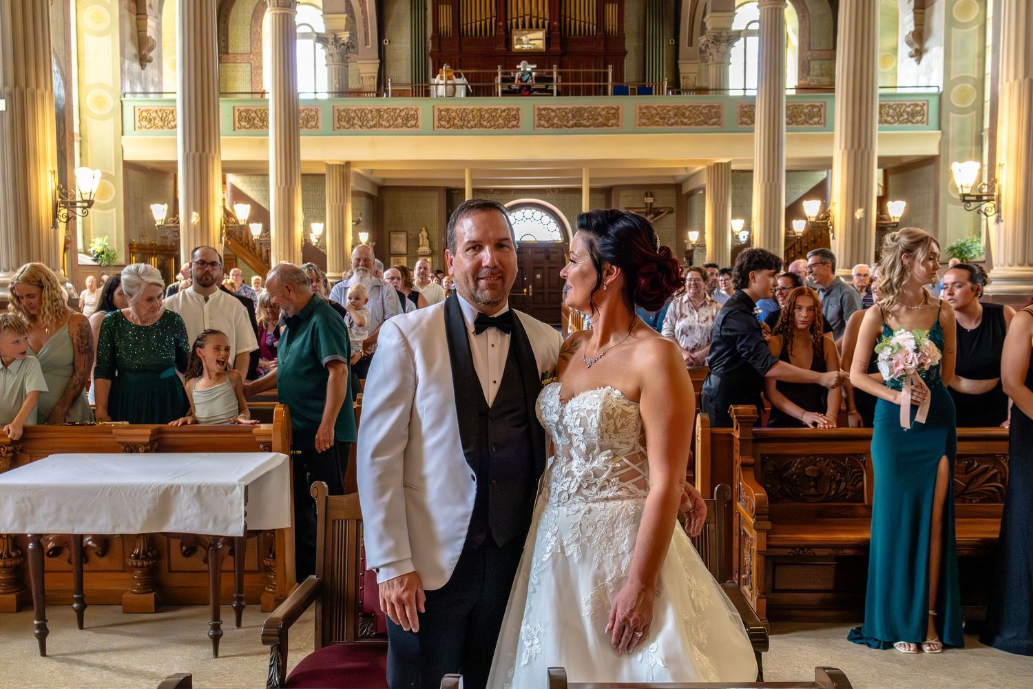 Bride and groom share a romantic moment at the altar inside an ornate church during their wedding ceremony.