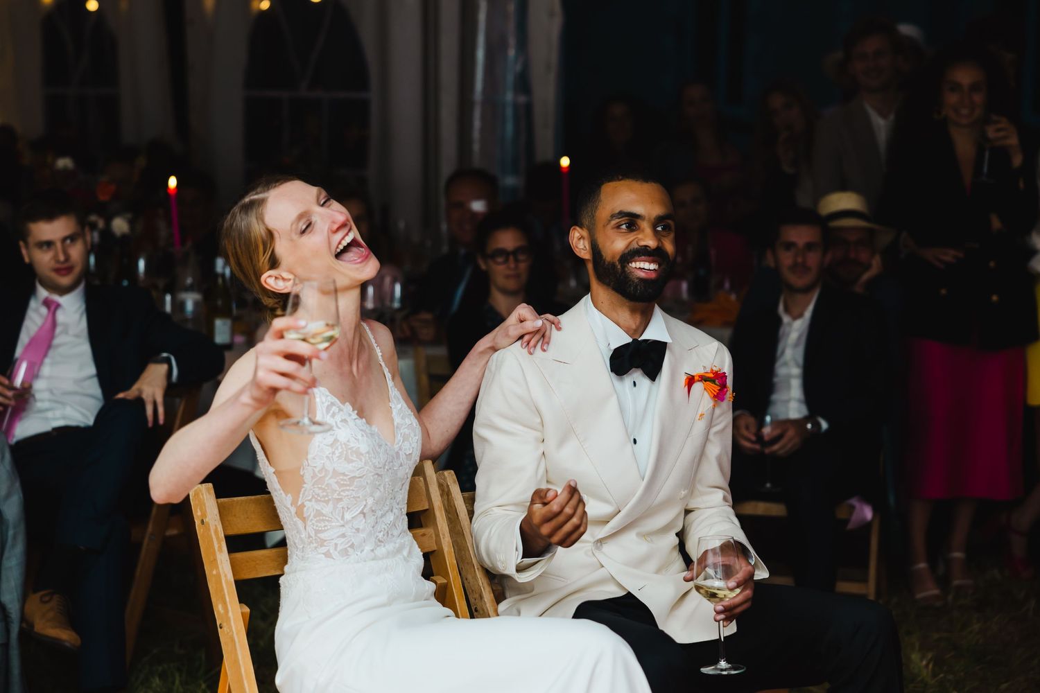 A group of people dancing and celebrating at a nighttime reception or party event.