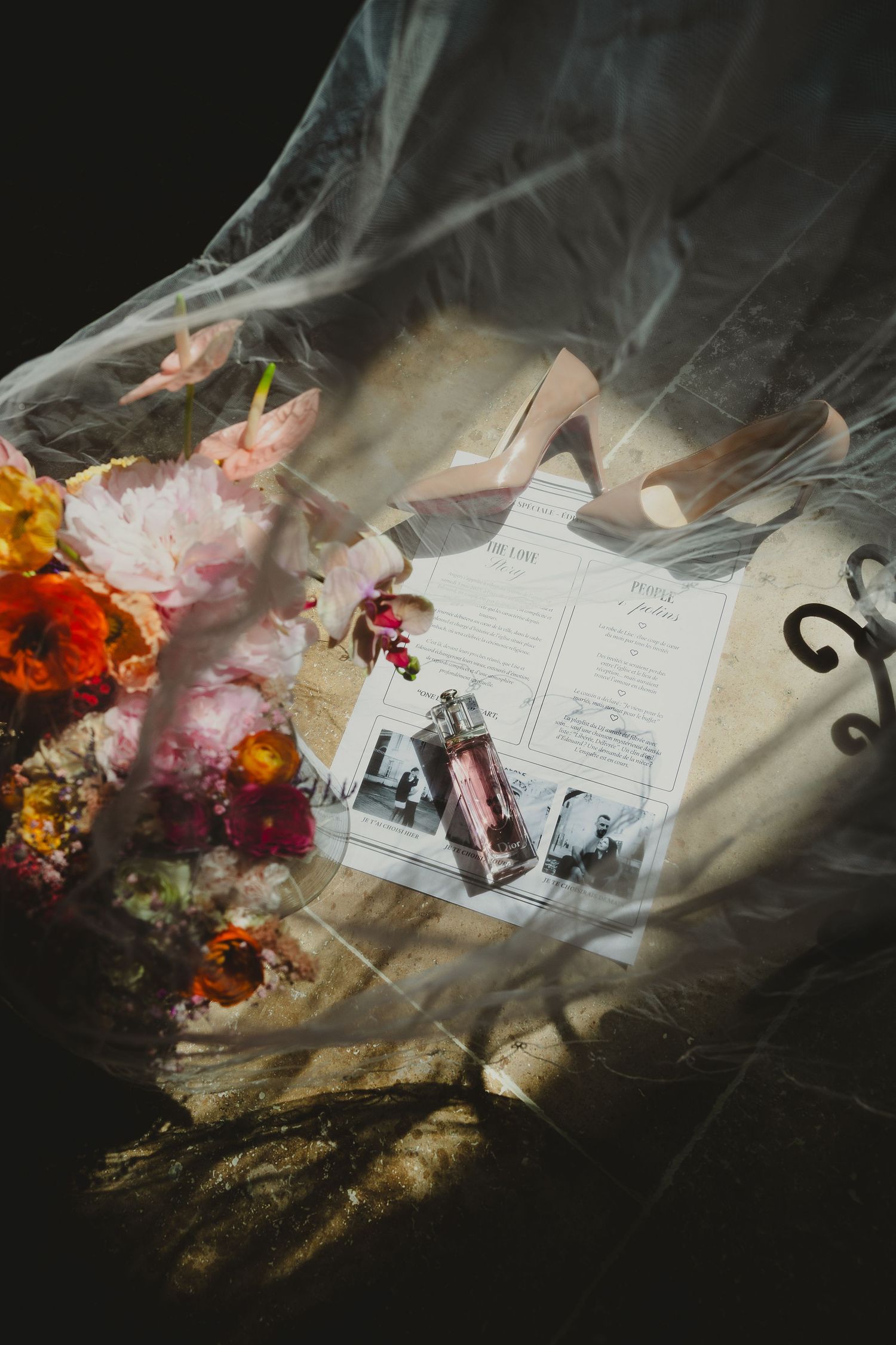 A dramatic still life arrangement with flowers and papers behind smoky glass creating an ethereal artistic composition.