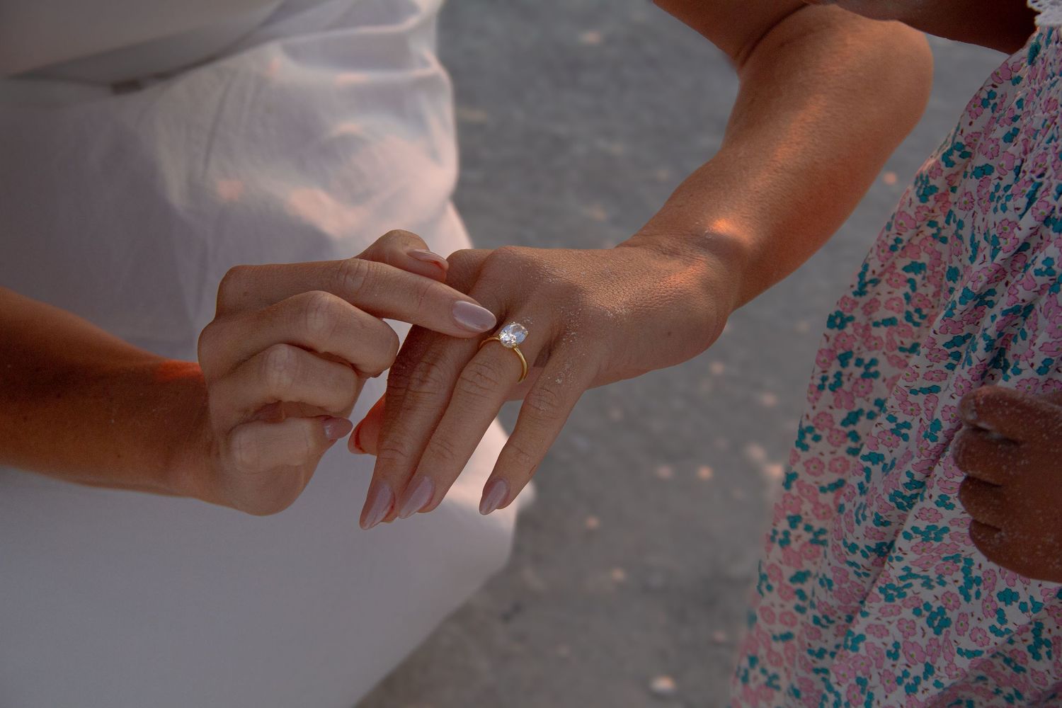 Close-up of a couple exchanging wedding rings during an outdoor ceremony, symbolizing love and commitment.