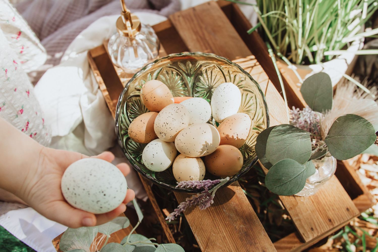 Natural Easter decor arrangement featuring eggs and eucalyptus on wooden surfaces.