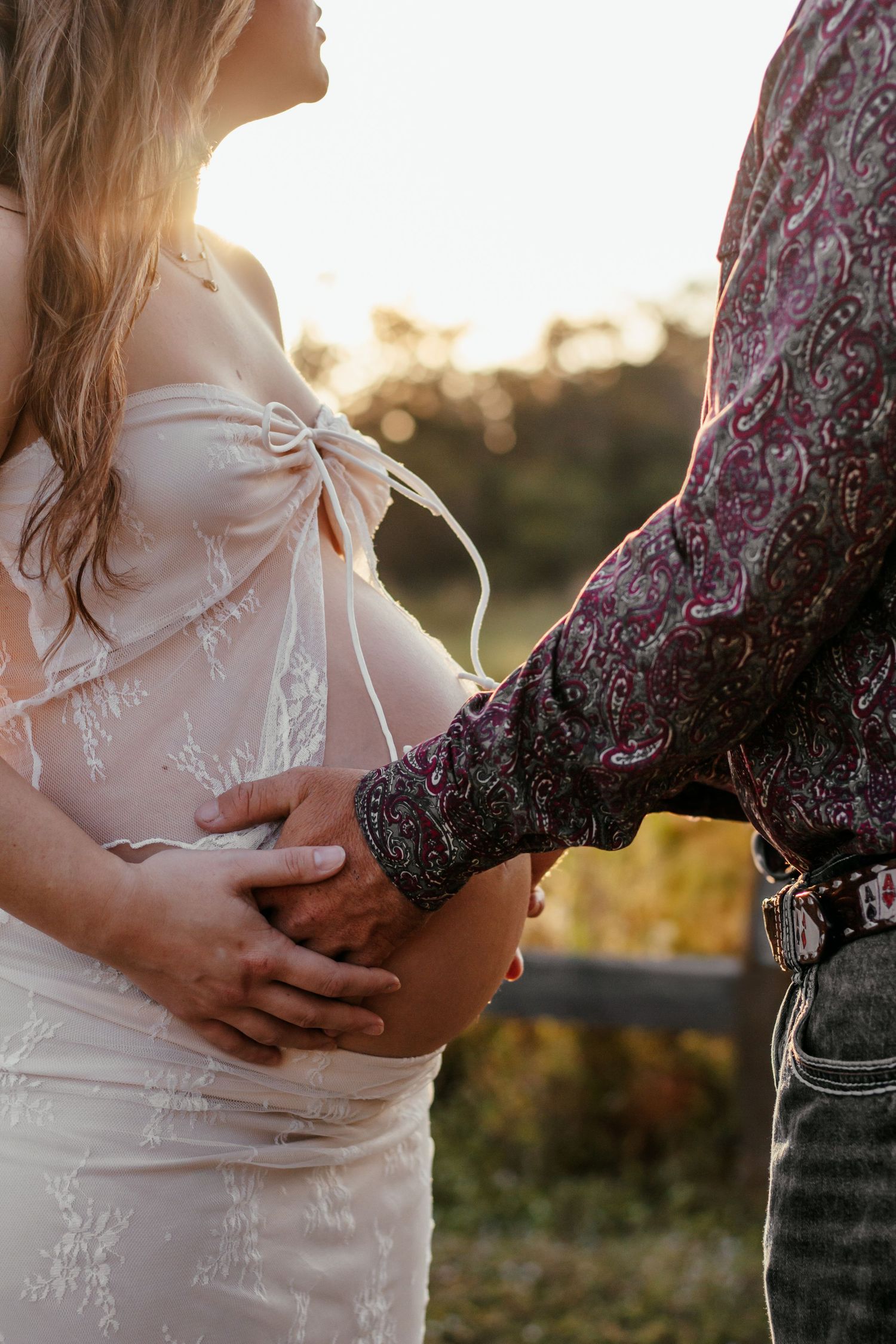 A series of maternity photos showing a pregnant belly in a white dress being embraced during golden hour sunset.