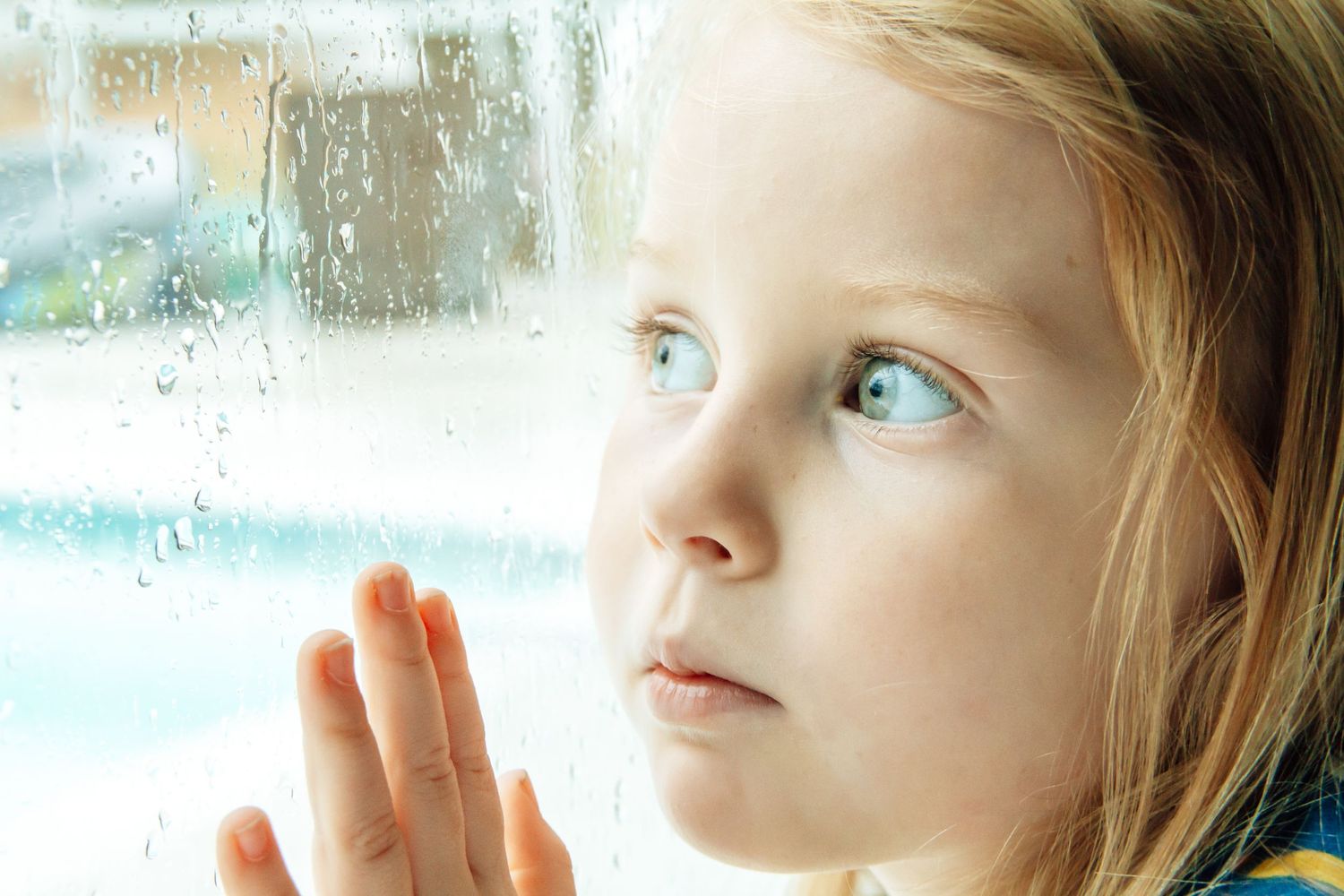 Profile view against window with natural lighting and water droplets.