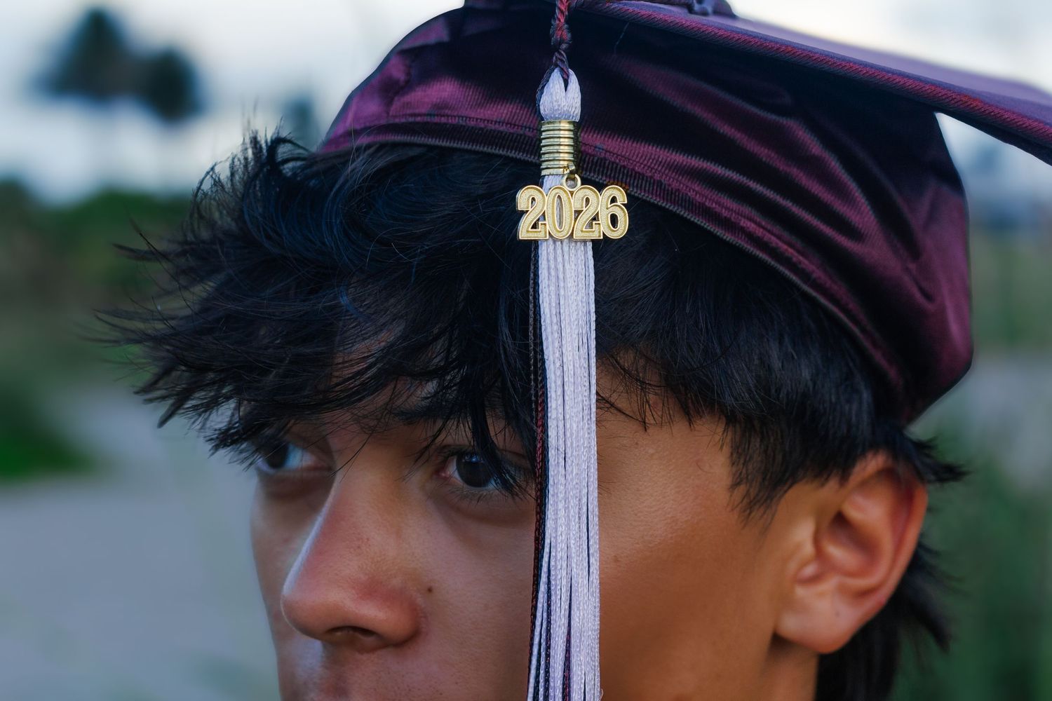 Close-up of a young man wearing a maroon graduation cap with a 2026 tassel, celebrating his upcoming graduation.