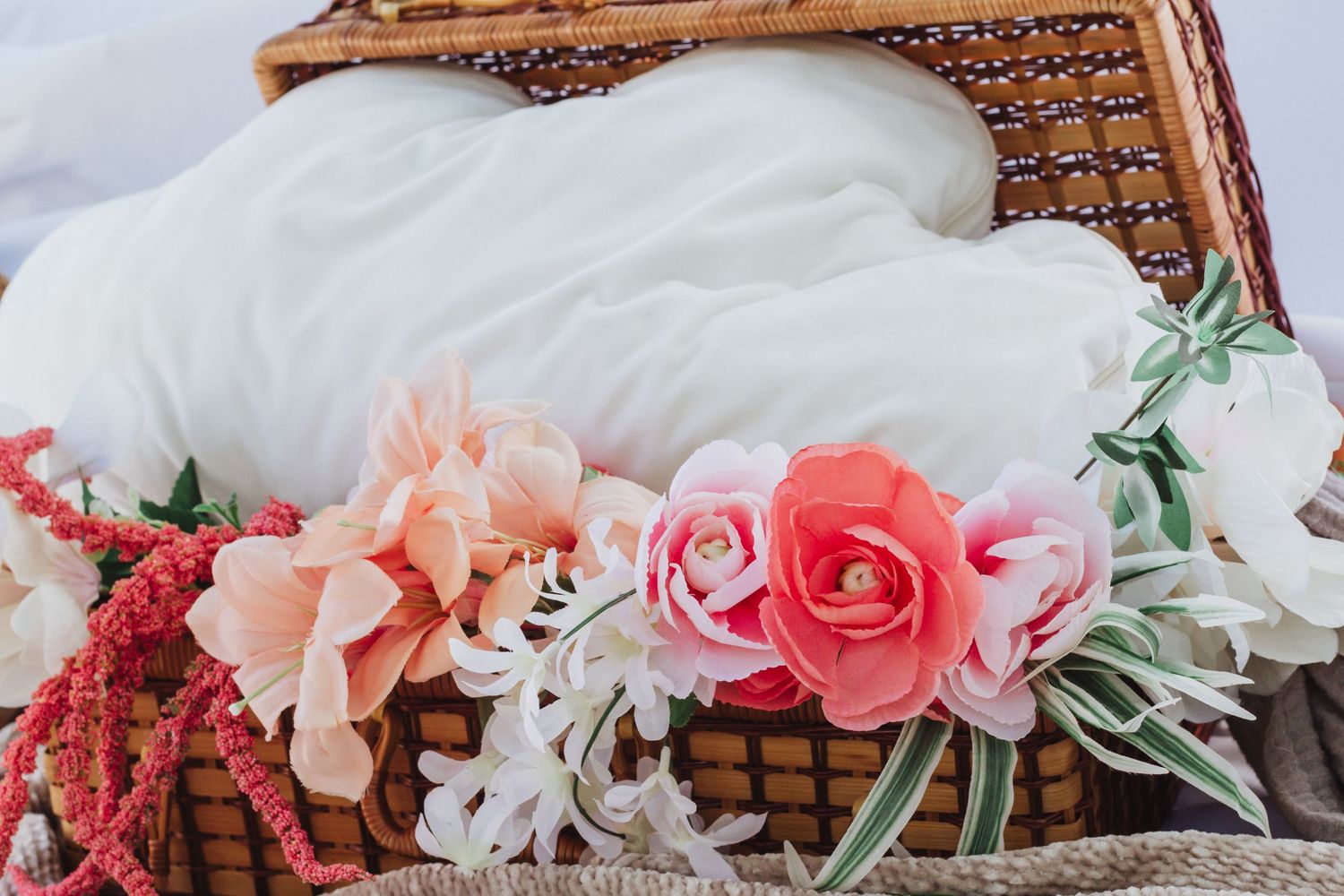 Bohemian style decor arrangement with wooden frame and pink and coral flowers.