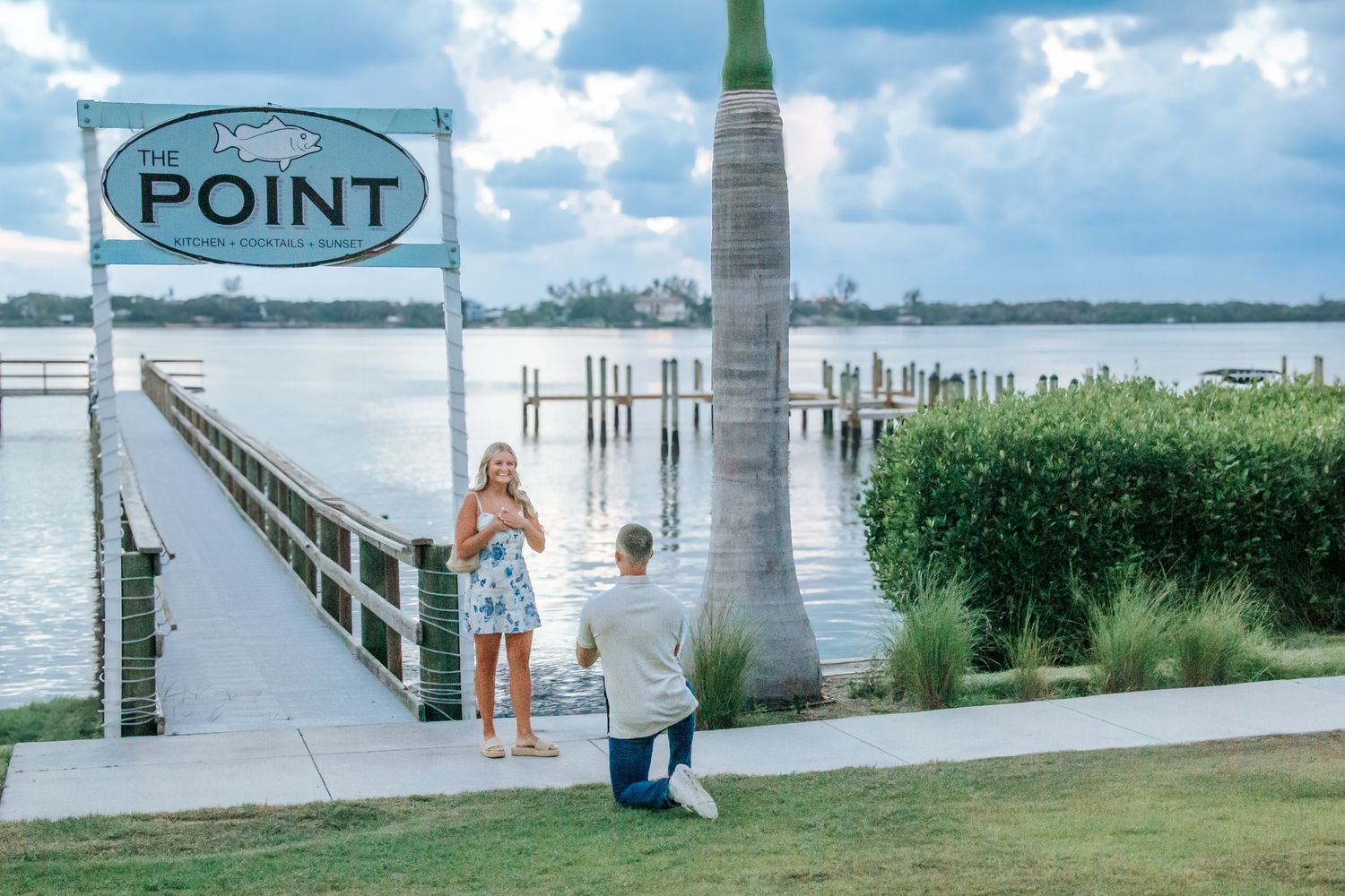 Man proposing to woman on a waterfront pier at The Point restaurant in Florida.