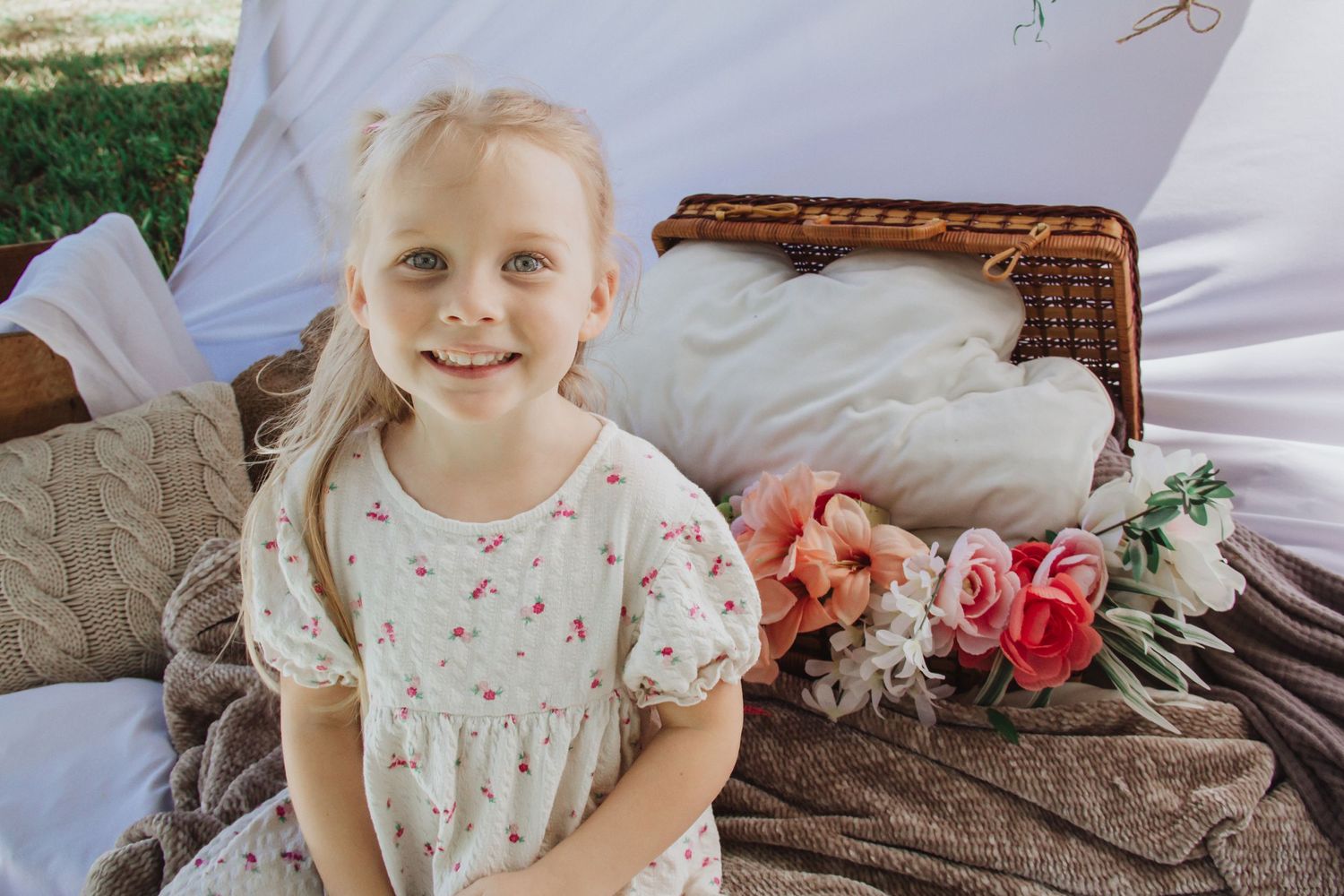 Close up floral setting with pink roses and scattered decorative eggs on a soft blanket or fabric.