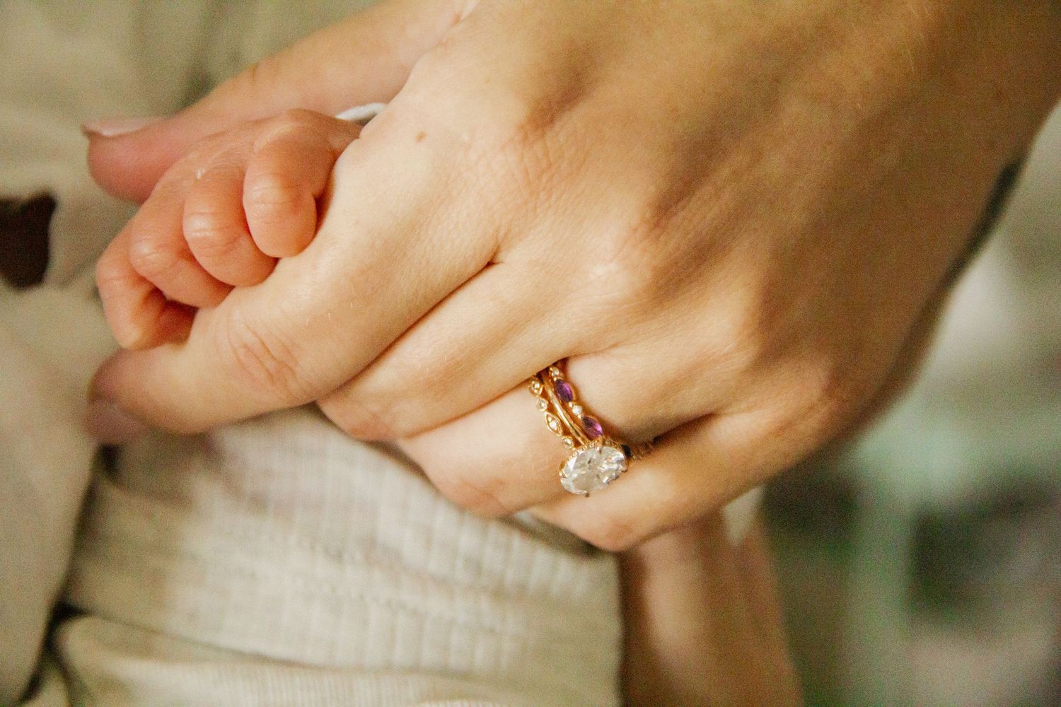 Close-up photo of hands showing off rose gold engagement ring with delicate detailing.
