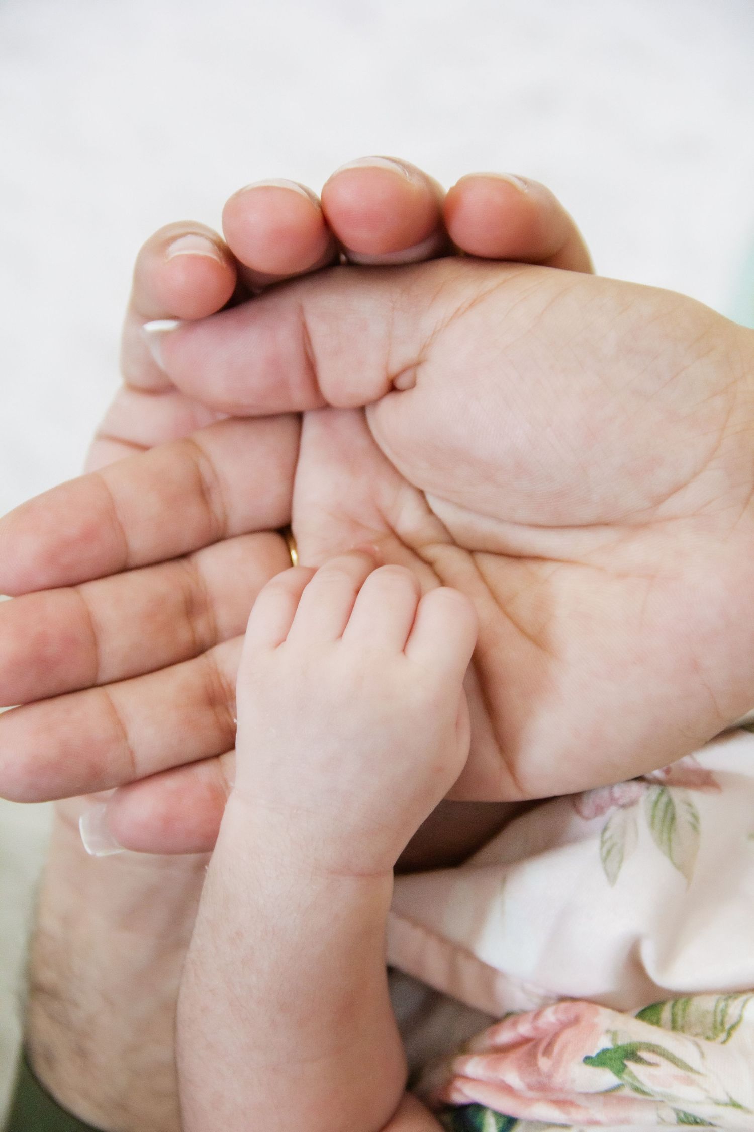 A tiny baby hand grasping an adult's open palm, symbolizing love and the bond between parent and child.