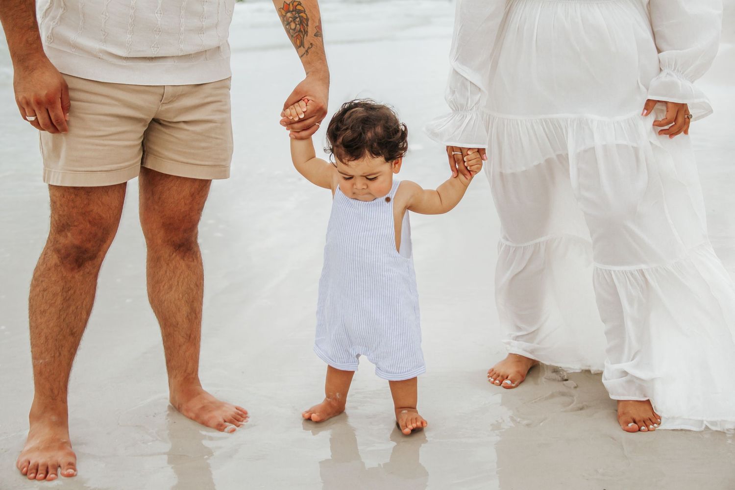 People wearing casual white outfits standing together with bare feet on a white floor creating a minimalist aesthetic.