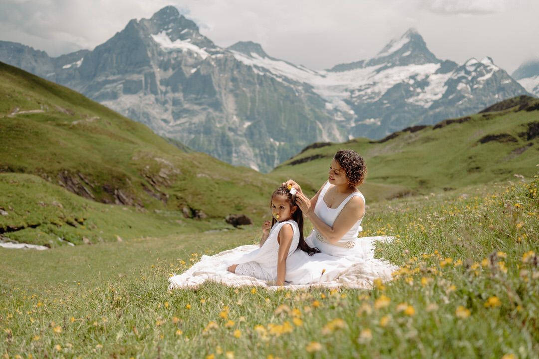 Scenic alpine meadow wedding photoshoot with majestic snow-capped mountain peaks in the background.