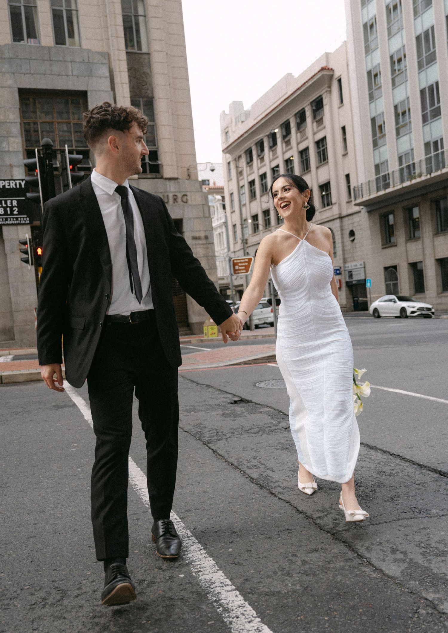 A series of candid wedding photos showing a couple walking together on a city street.