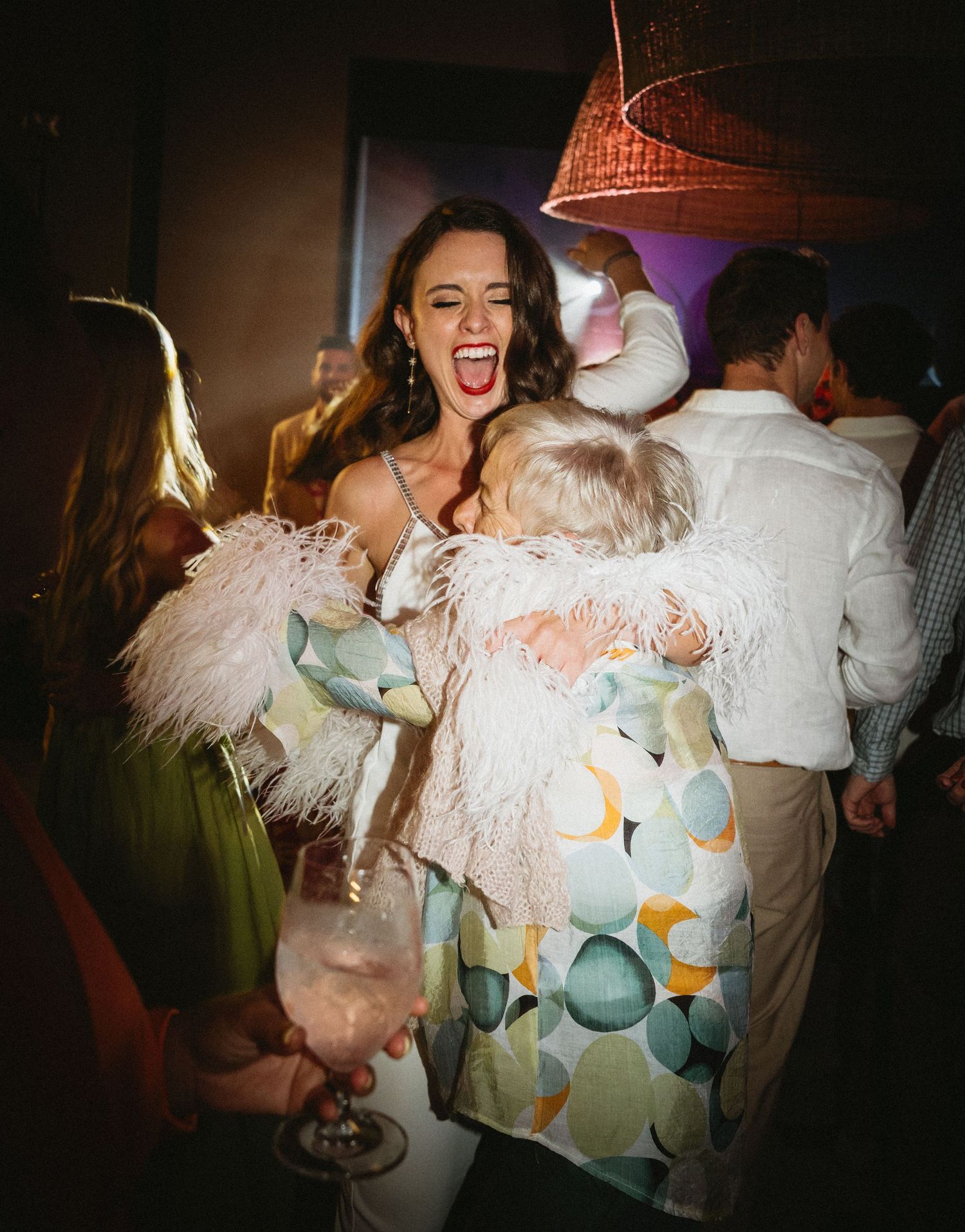 Joyful celebration scene at a party with festive attire and ambient lighting.