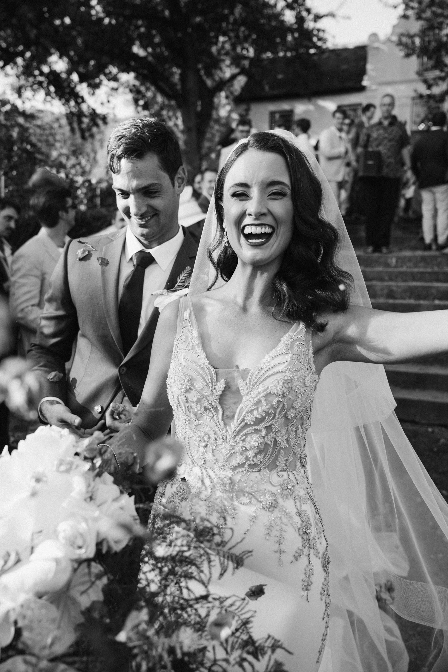 Candid black and white photo capturing pure joy during a wedding celebration.