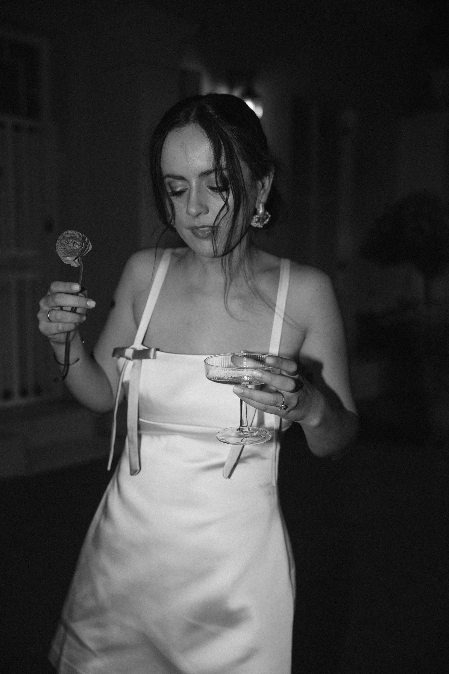 Black and white photo series showing someone in a white dress holding a cigarette and lighter in dark lighting.