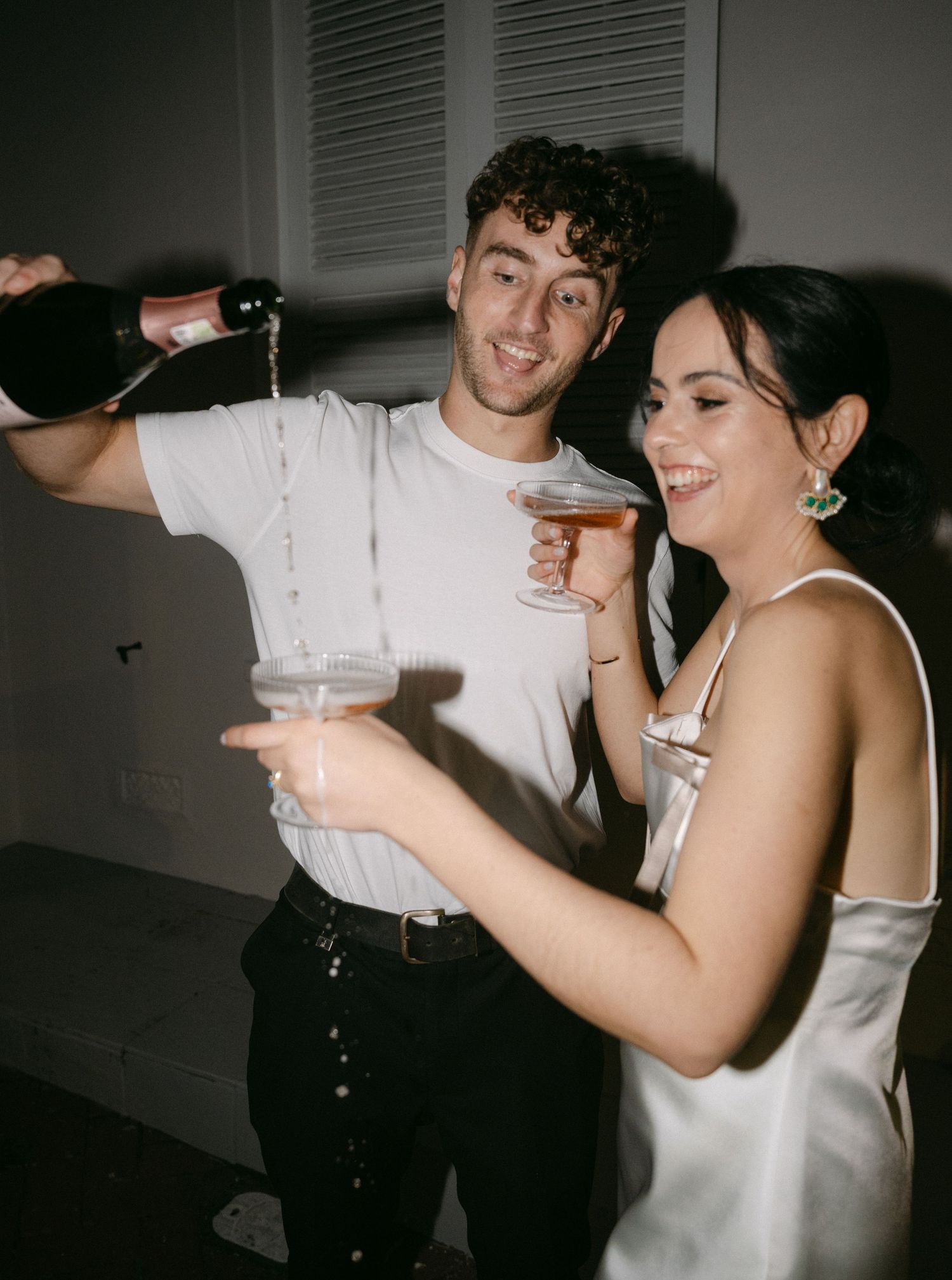 A couple in wedding attire share a joyful dance moment together at their reception celebration.