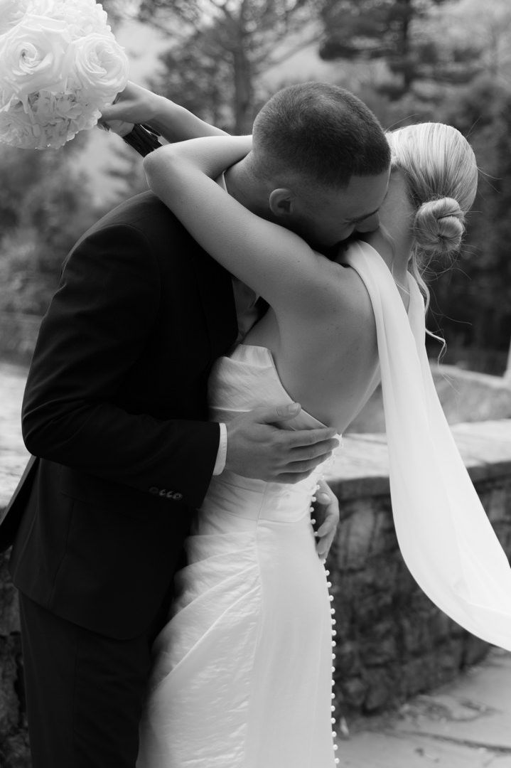 A romantic black and white wedding photo capturing a tender embrace between newlyweds outdoors. Villa emden wedding
