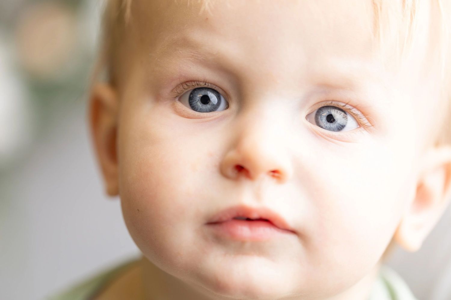 Close-up portrait showing bright blue eyes and delicate features.