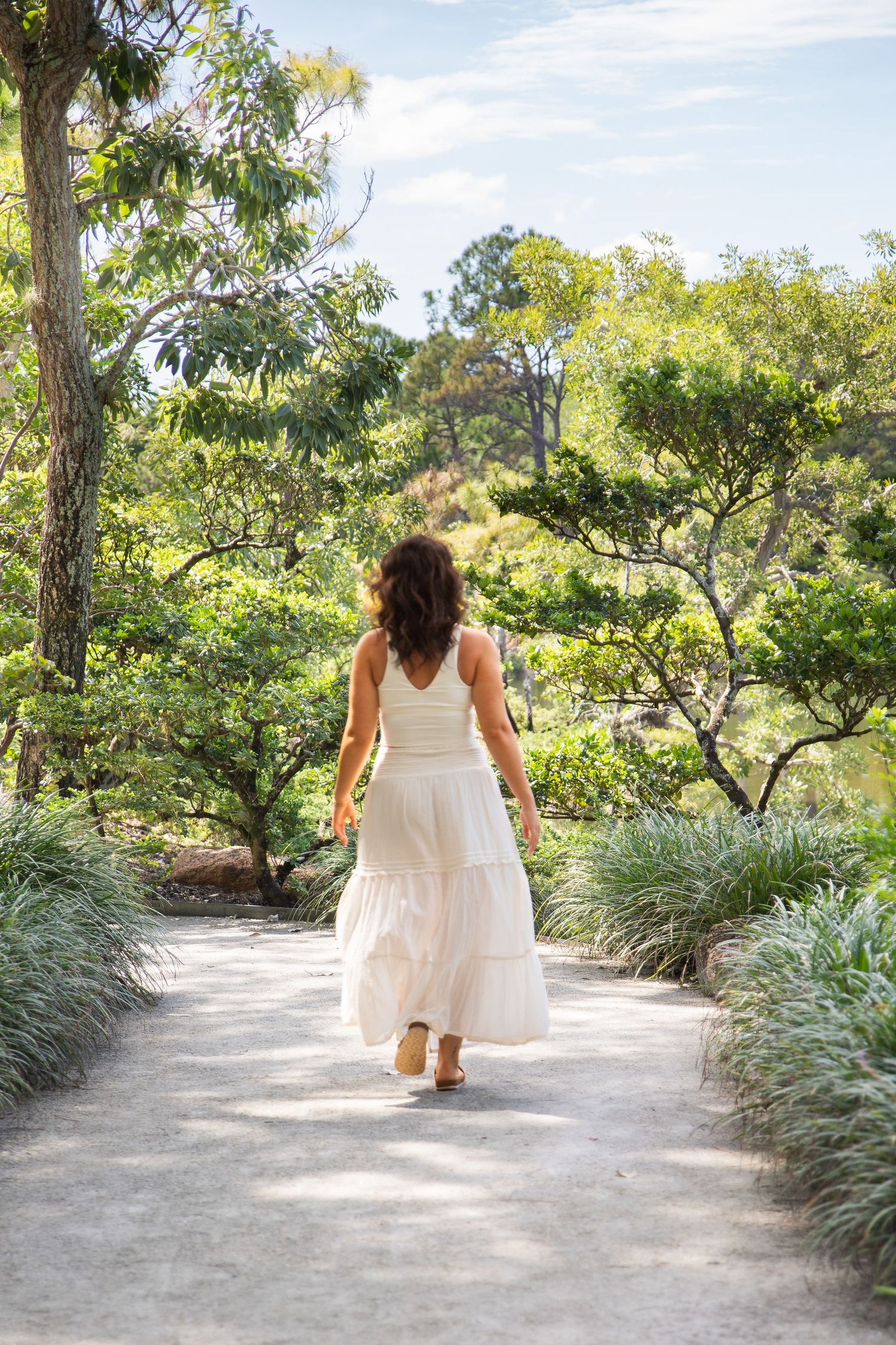A series of outdoor portraits along a winding garden path bordered by lush ornamental grasses.