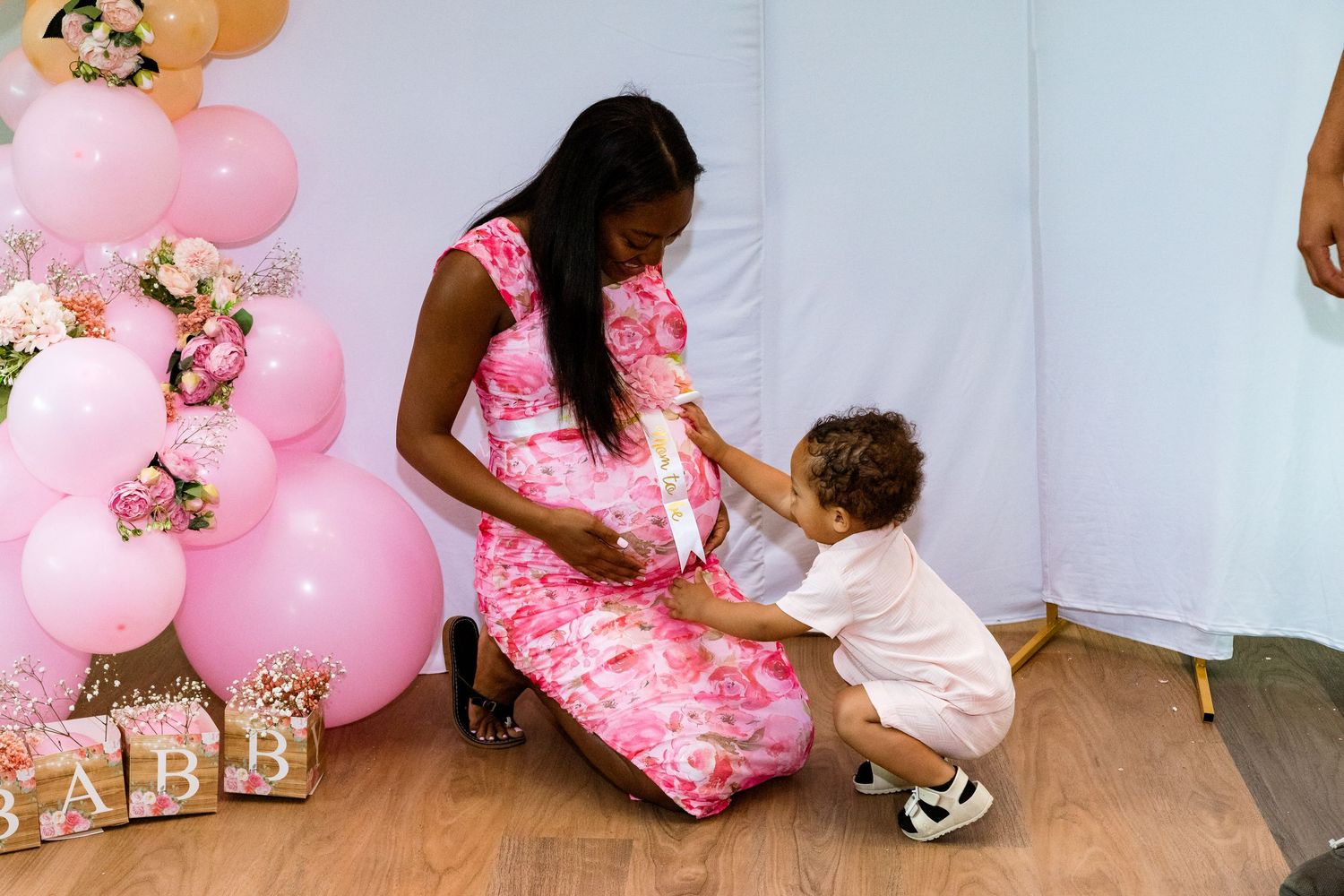 A pink balloon display with decorative boxes in the corner.