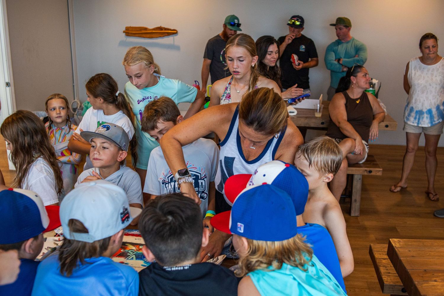 A large group of people gathered indoors participating in what appears to be a social or community event.