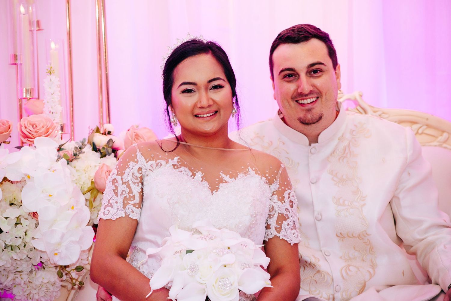 Wedding celebration scene with pink lighting and white lace decorations.