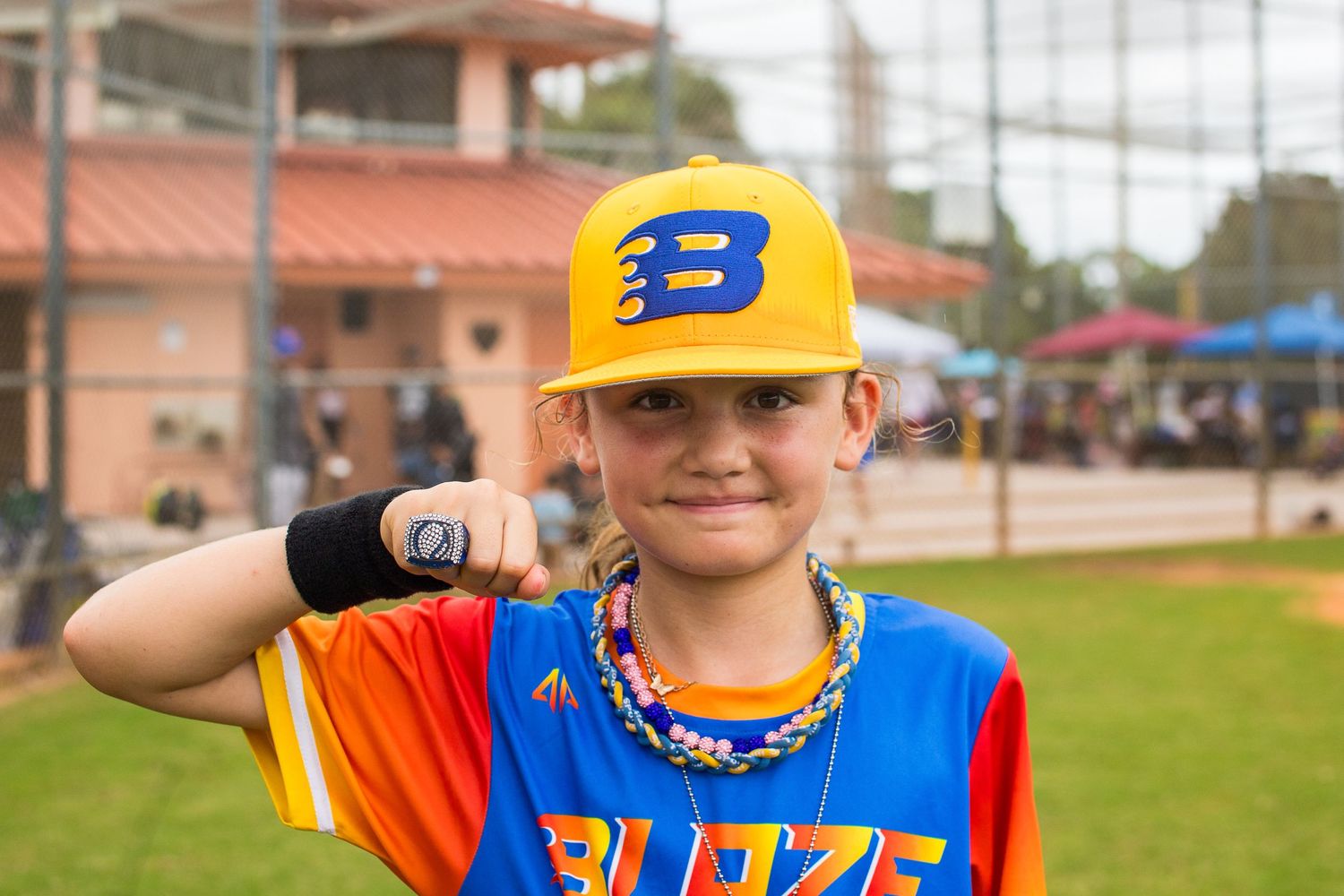 Young baseball player in Blaze uniform proudly displays team spirit with confident pose.