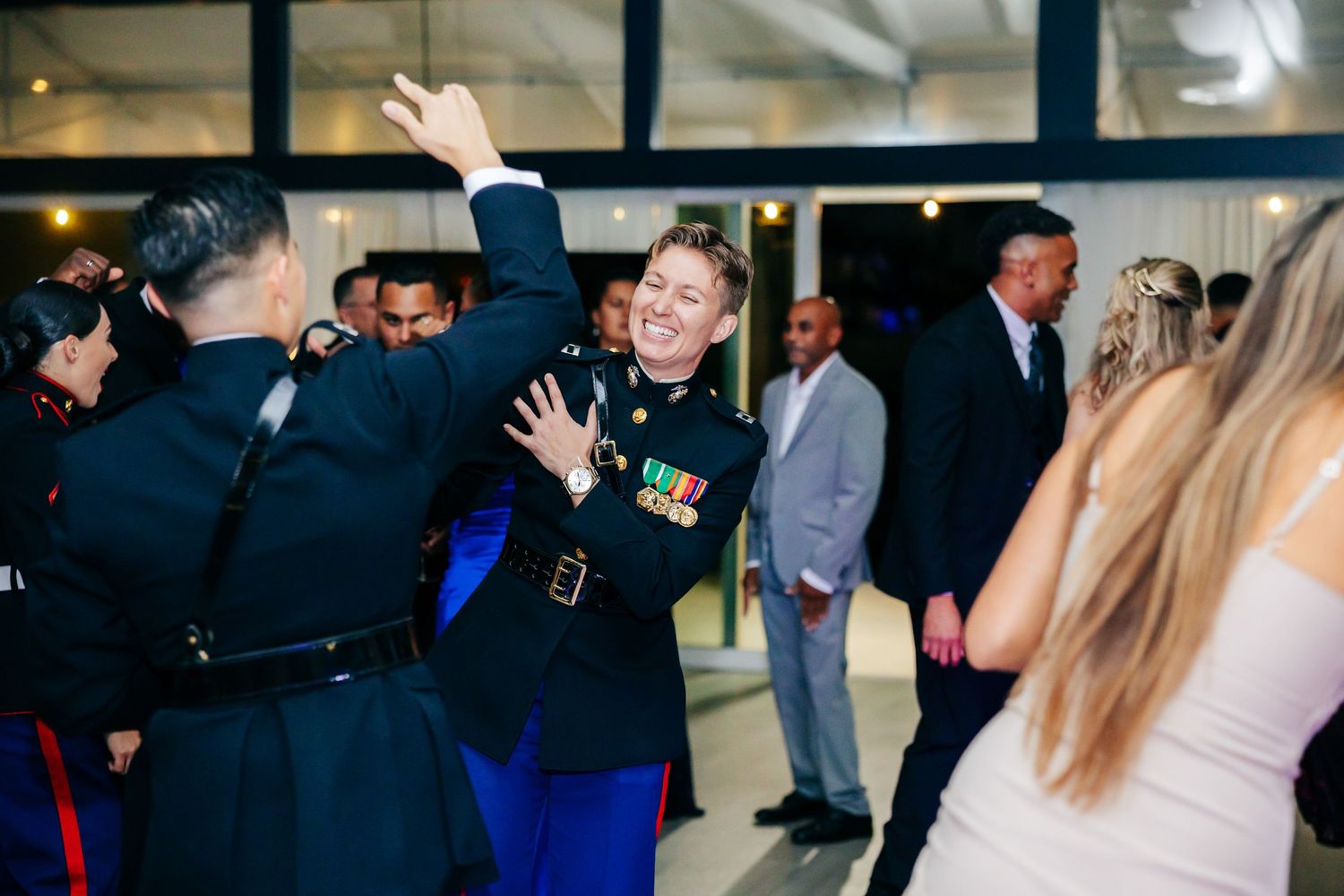 Guests mingling and dancing at an elegant Marine Corps celebration event.