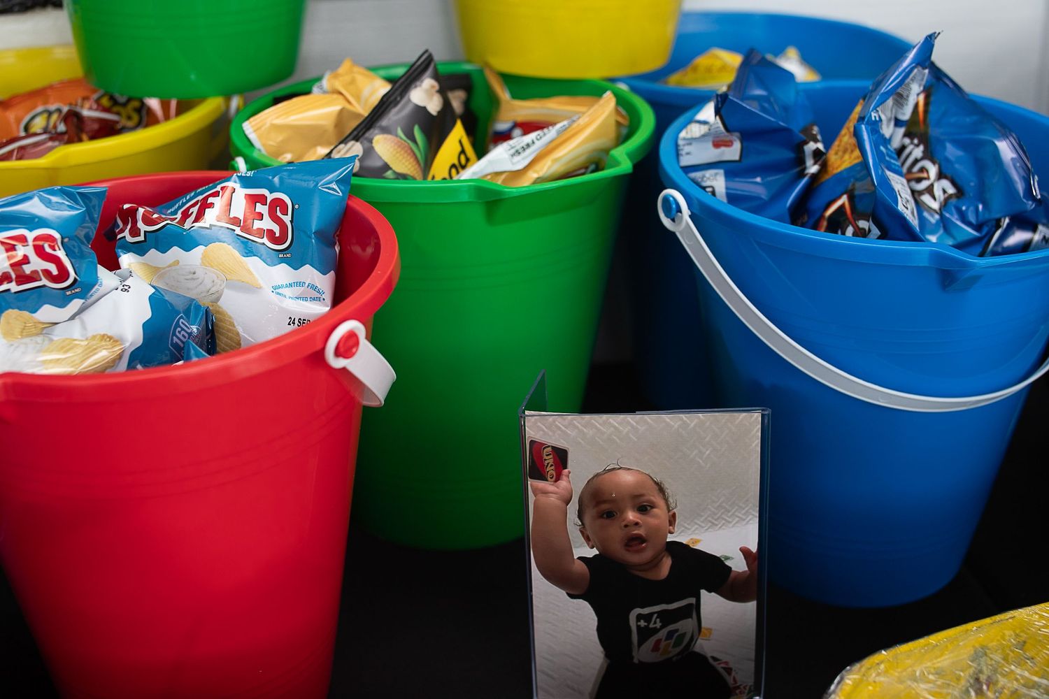Colorful plastic buckets filled with snacks and treats at a party.